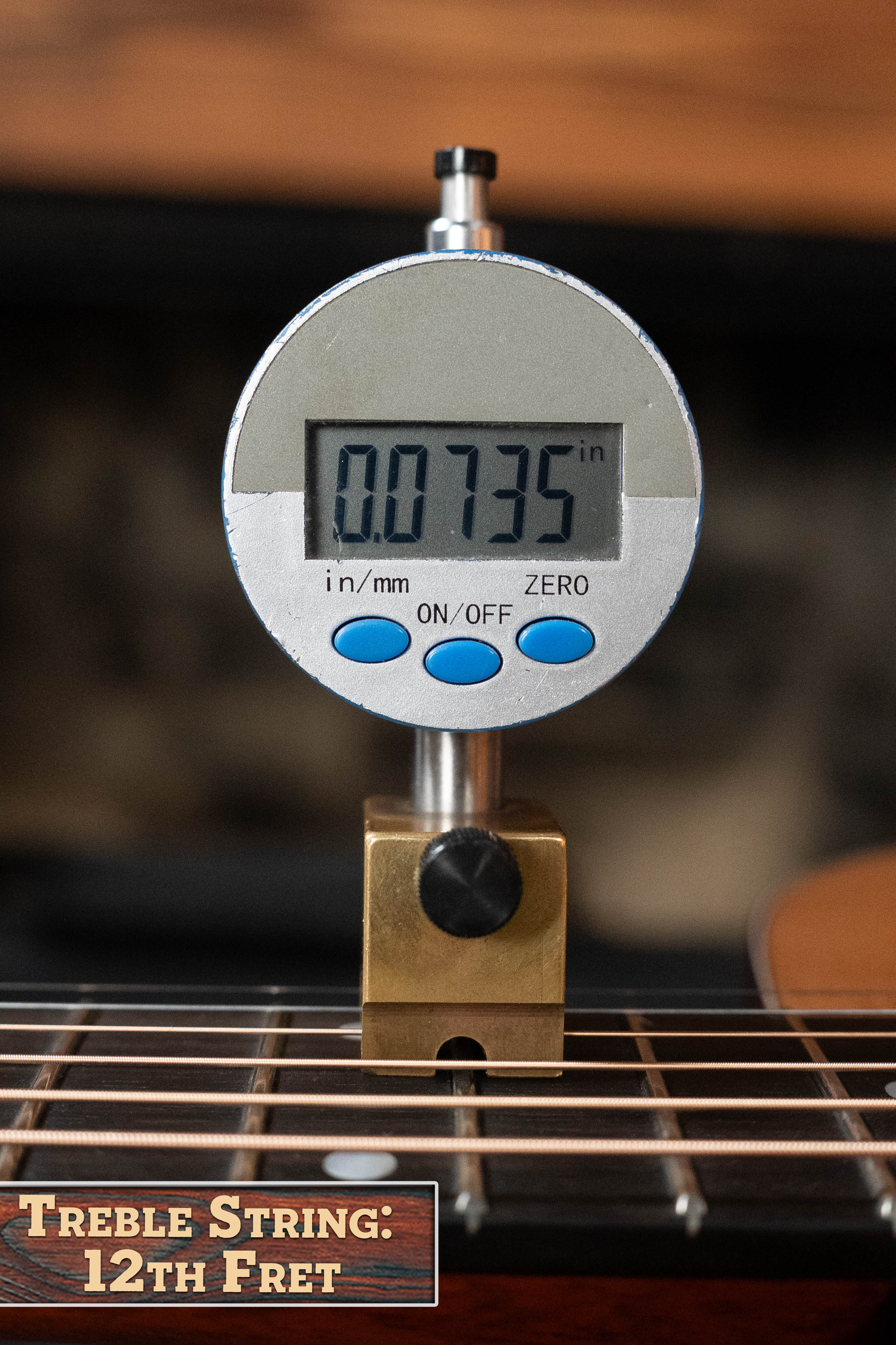 A digital gauge reads 0.0735 inches, measuring the treble string height above the 12th fret on an Eastman Guitars E2OM Cedar/Sapele Orchestra Model Acoustic Guitar #9002. Label reads: Treble String: 12th Fret.