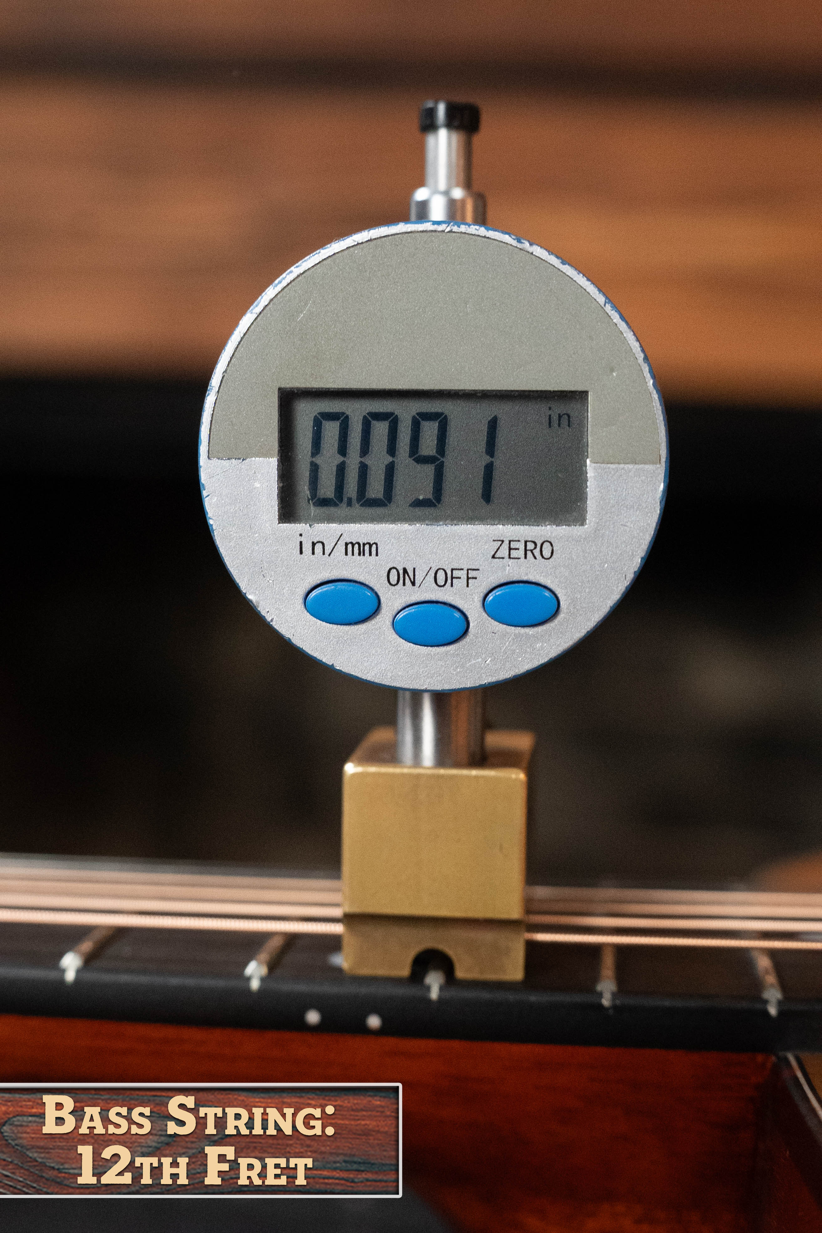 A digital gauge reads 0.091 inches, showing the Bass String height at the 12th fret on an Eastman E2OM Cedar/Sapele Acoustic Guitar #9010 by Eastman Guitars.
