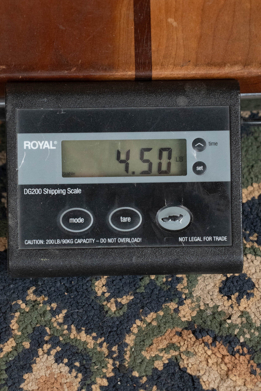 A digital shipping scale on patterned carpet shows 4.50 lbs—the weight of an Eastman Guitars E40OM-TC AAA Grade Thermo-cured Adirondack/Rosewood Orchestra Model Acoustic Guitar #4586. The scale's max capacity is 200lb/90kg.