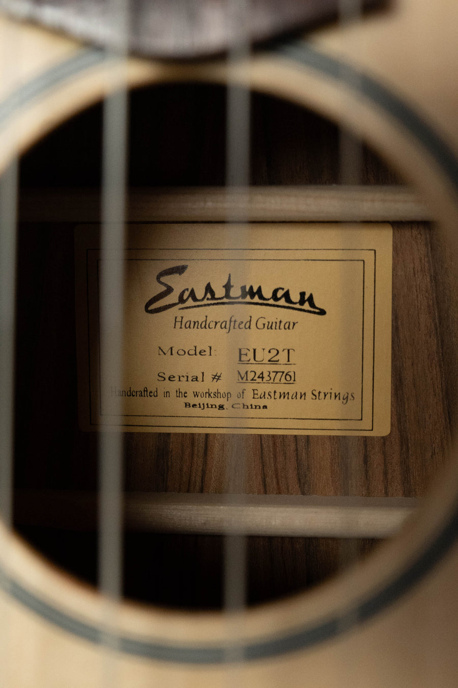Close-up of an Eastman Guitars EU2-T Spruce/Ovangkol Tenor Ukulele #7761 soundhole reveals its label and craftsmanship, highlighting the brand’s quality build.