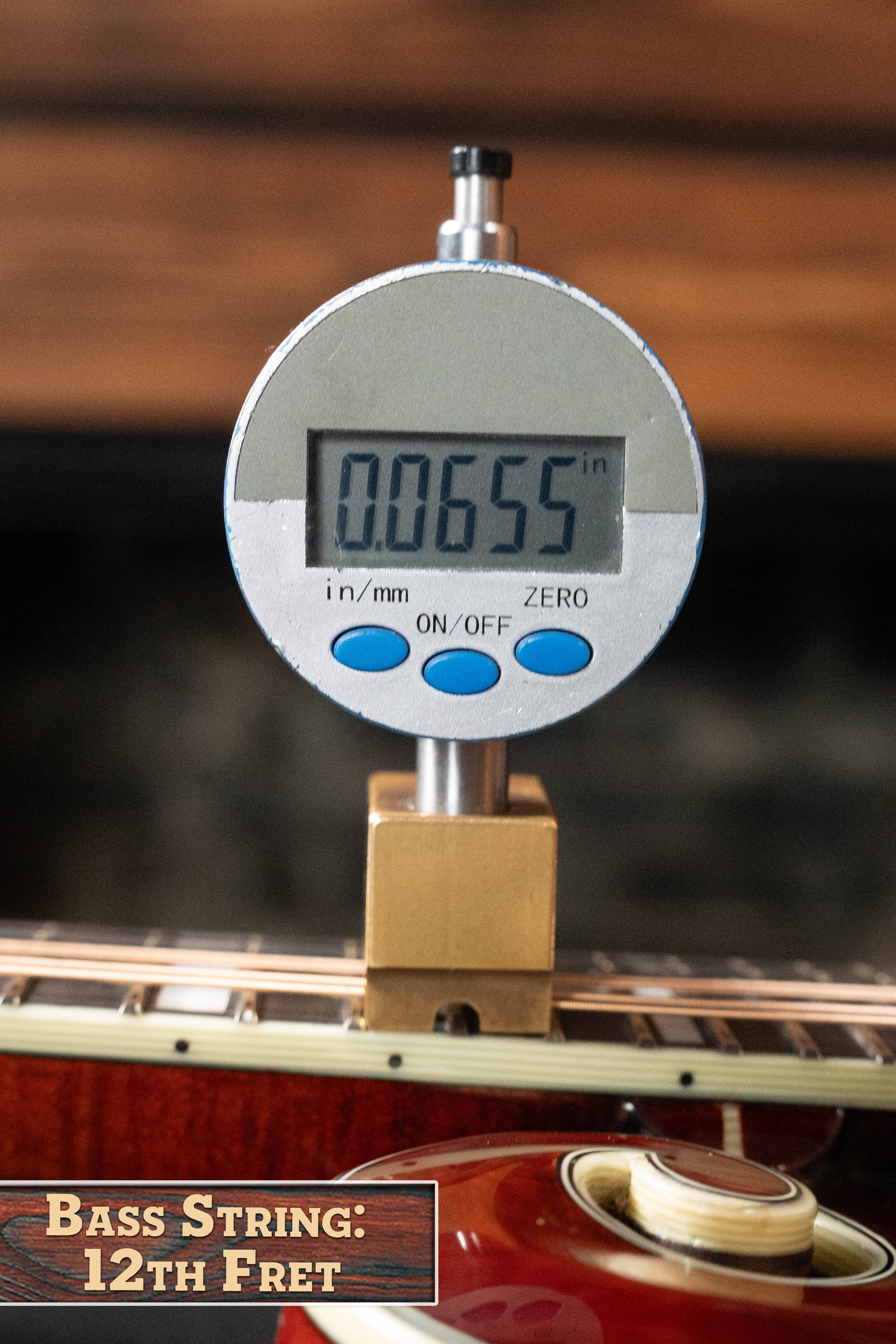 A digital caliper reads 0.0655 inches above the 12th fret of a string on the Eastman MD615 Spruce/Maple F-Style Mandolin w/K&K Pickup by Eastman Guitars, its reddish wooden body recalling artisan craftsmanship. A text box reads: Bass String: 12th Fret.