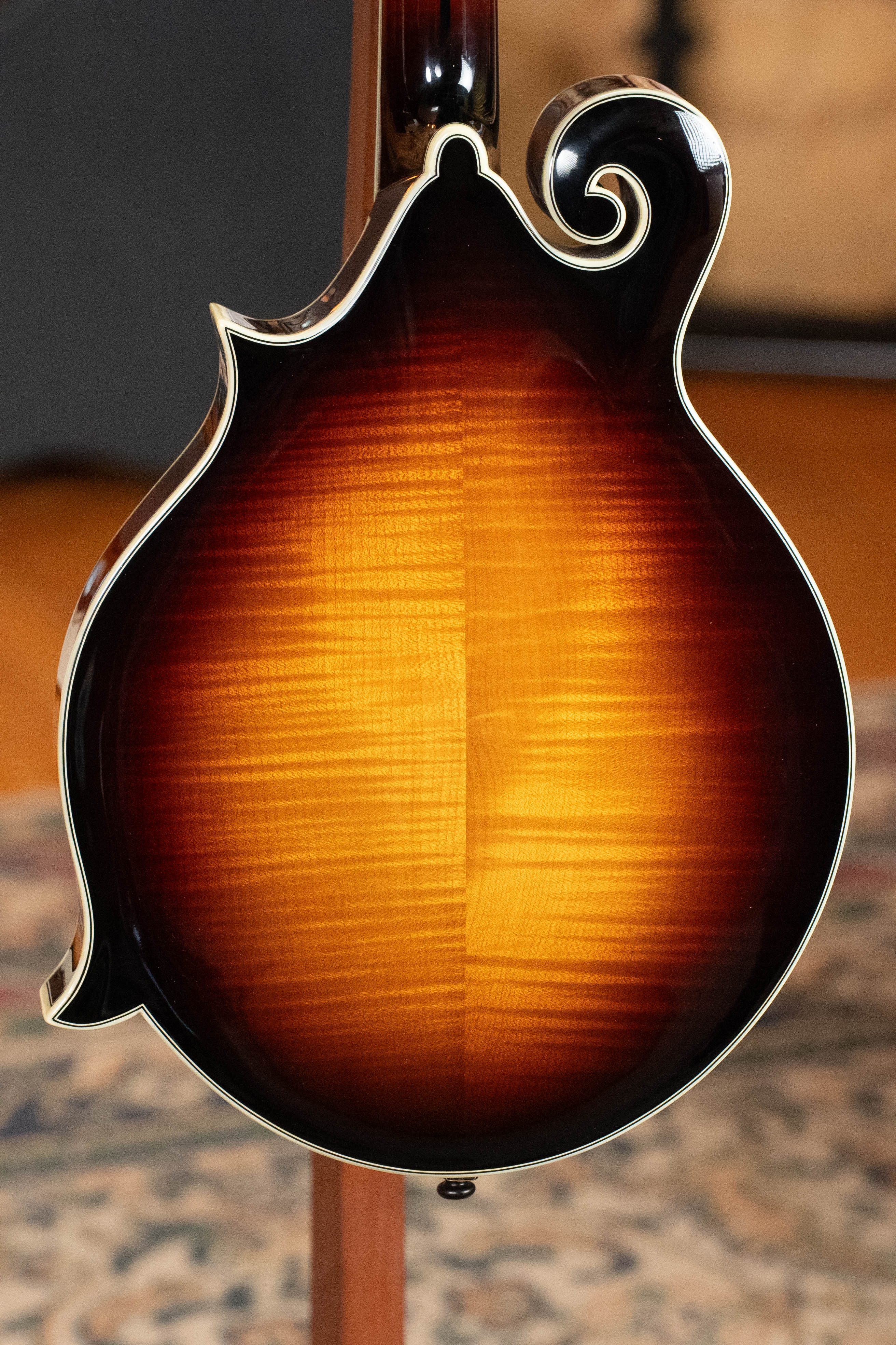 A close-up of the Eastman Guitars MD815-SB Adirondack/Flamed Maple Sunburst F-Style Mandolin #3356 highlights its fine details and stunning sunburst finish.