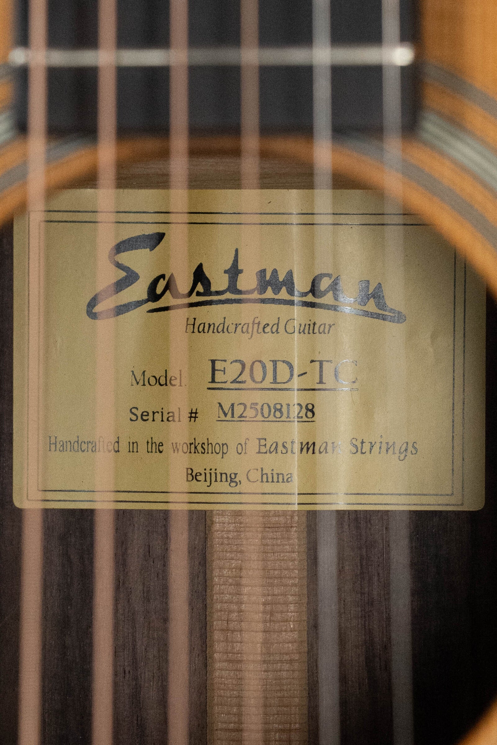 Close-up of a label inside the sound hole of an Eastman Guitars E20D-TC Thermo-Cured Adirondack/Rosewood Dreadnought Acoustic Guitar #8128, handcrafted in Beijing, China.