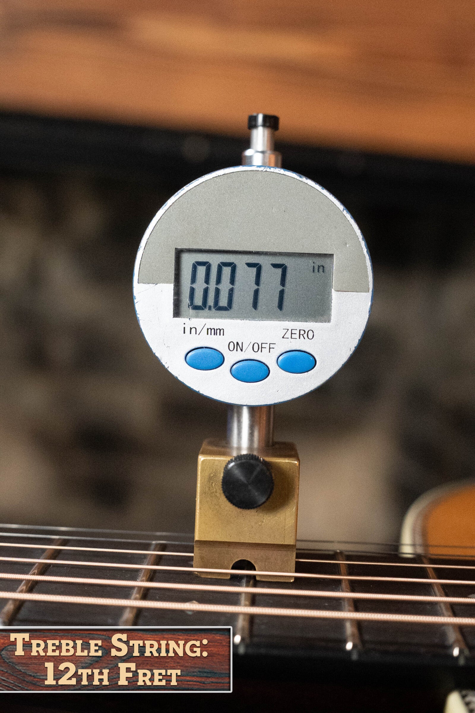 A digital gauge shows 0.077 inches on the treble string at the 12th fret of an Eastman Guitars E20D-TC Thermo-Cured Adirondack/Rosewood Dreadnought Acoustic Guitar #8128, with a label reading Treble String: 12th Fret.