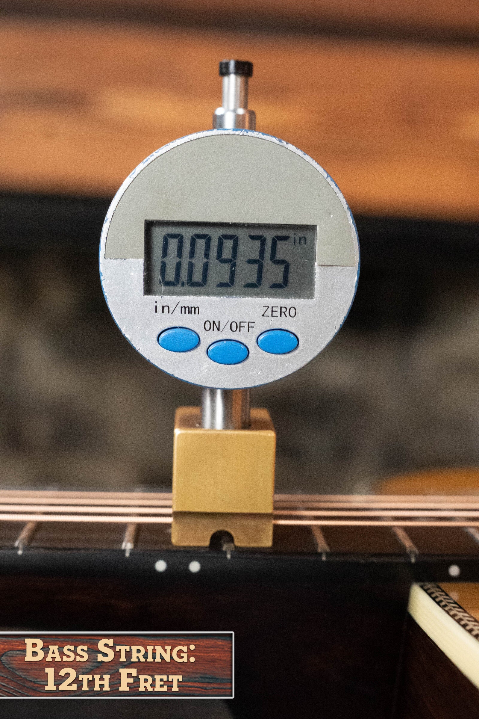 A digital caliper shows 0.0935 inches for the bass string height at the 12th fret on an Eastman Guitars E20OM-TC Thermo-Cured Adirondack/Rosewood Orchestra Model Acoustic Guitar #3015. Label: Bass String: 12th Fret.
