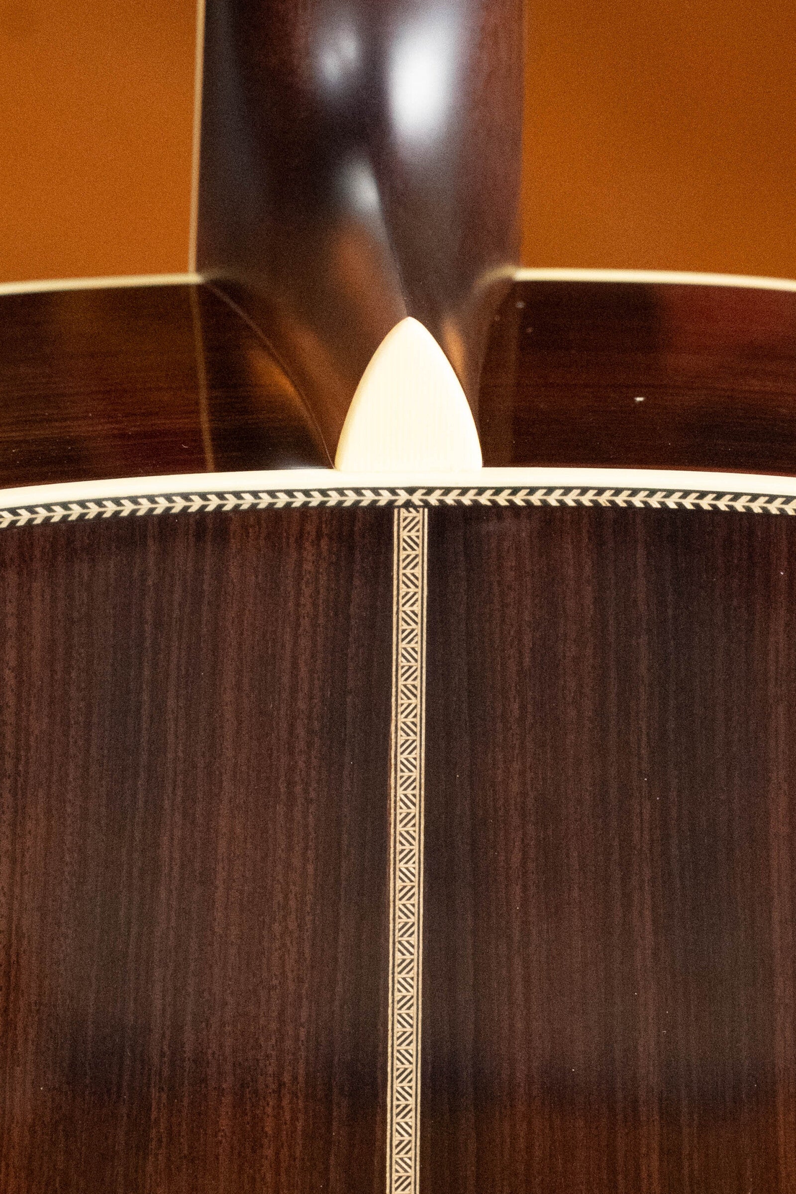 Close-up of the rosewood back and sides on the Eastman Guitars E40D-TC-SB #1113 Dreadnought, highlighting the dark wood grain, center inlay strip, and light heel cap at the neck joint.