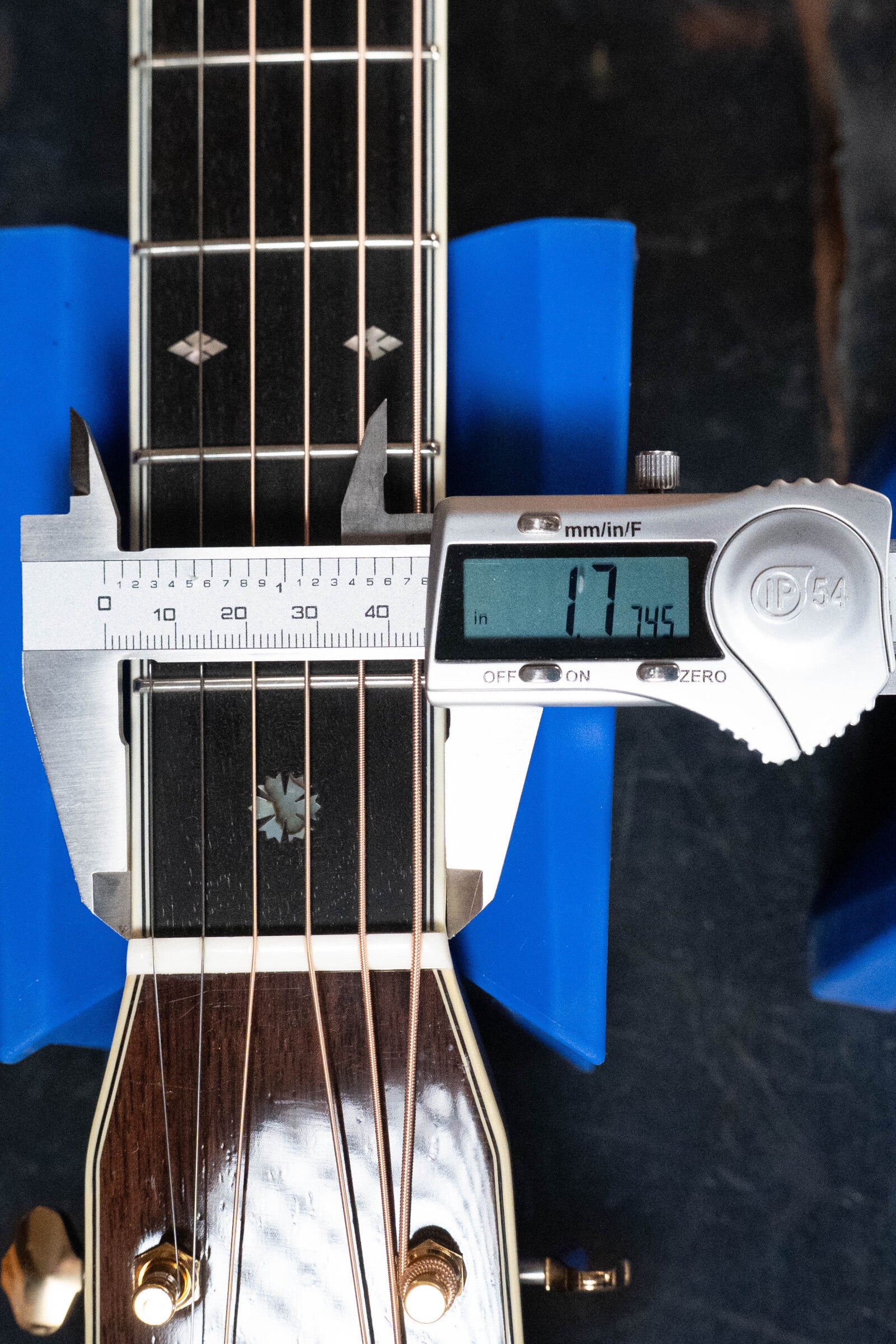 A digital caliper measures the neck width of an Eastman Guitars E40D-TC-SB Thermo-cured Sunburst Dreadnought Acoustic Guitar #1113 at 1.7745 inches, with its Rosewood back, sides, headstock, strings, and blue supports visible.