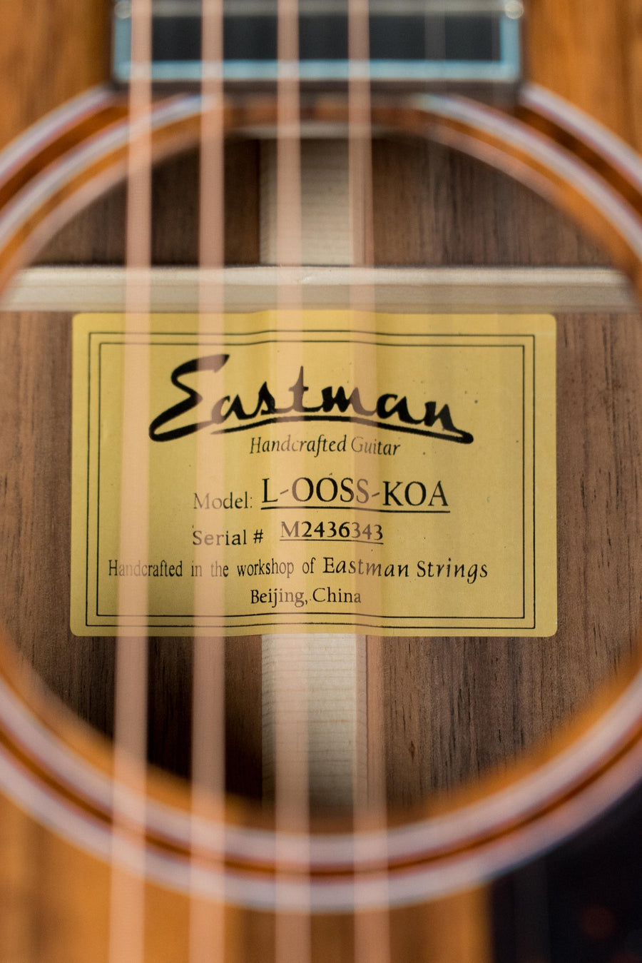 Close-up of Eastman L-OOSS-LTD-KOA acoustic guitar label with koa wood body and strings visible. - Eastman L-OOSS-LTD-KOA Limited Edition Luthier Series All Koa Acoustic Guitar #6343 - Default Title