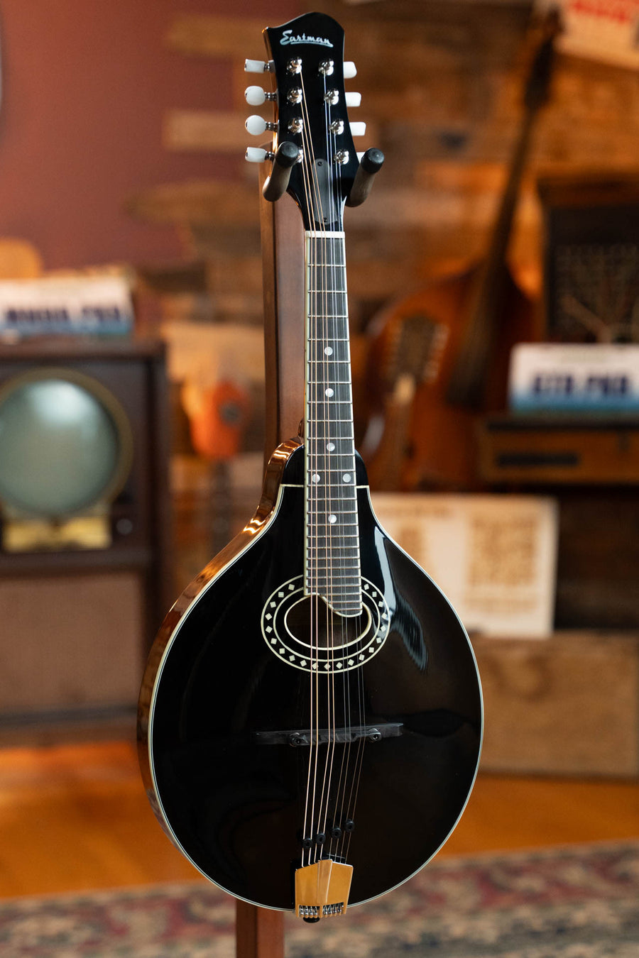 Black A-style mandolin with oval sound hole, decorative rosette, and wooden tailpiece. - Eastman MD404-BK Black Top Oval Hole A-Style Mandolin #0083 - Default Title