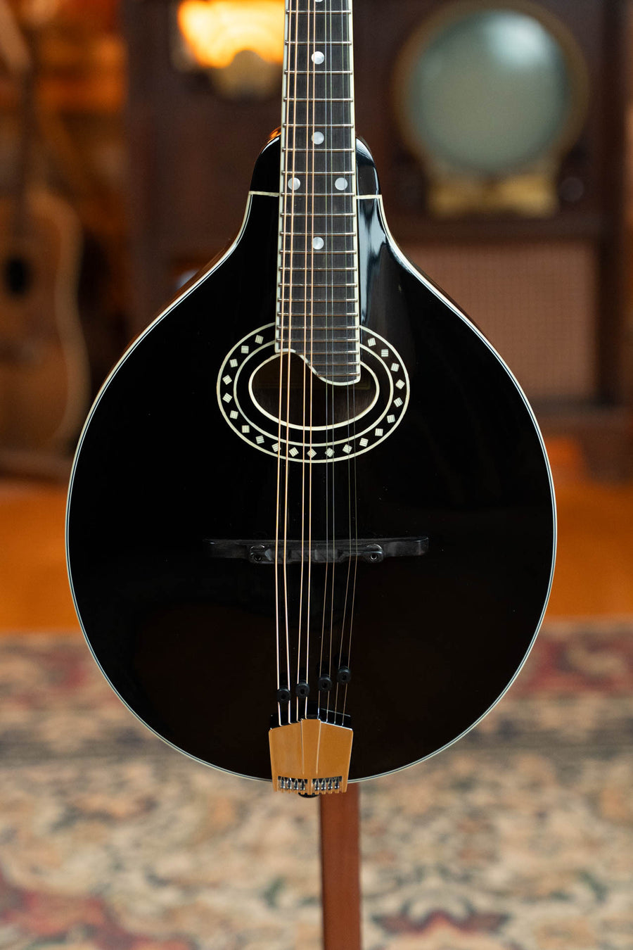 Black A-style mandolin with oval sound hole, decorative rosette, glossy finish, and wooden bridge. - Eastman MD404-BK Black Top Oval Hole A-Style Mandolin #0083 - Default Title