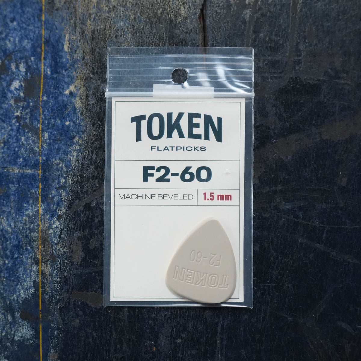 Token F2-60 TAN Flatpick 1.5mm in a plastic bag with a label.