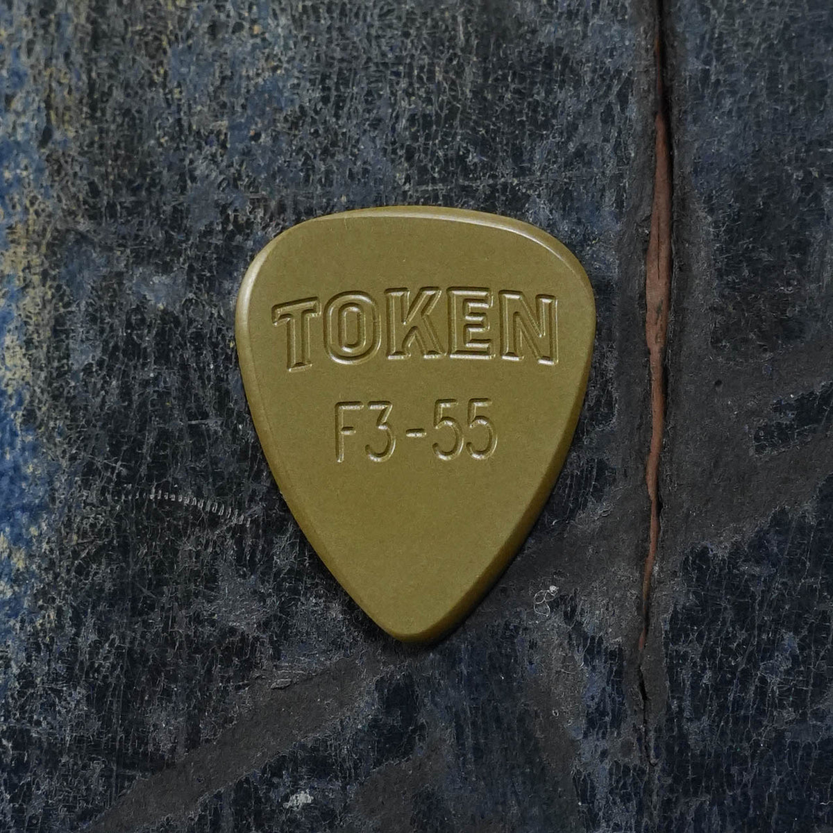 Token F3-55 Green Flatpick, teardrop 1.4mm, front view with embossed TOKEN and F3-55 logo.