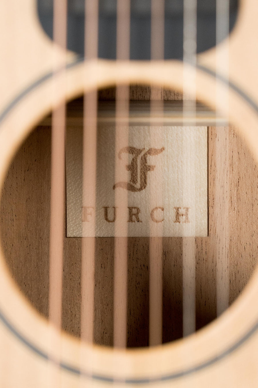 Close-up of Furch acoustic guitar soundhole with natural Sitka spruce top and mahogany interior, visible strings and logo. - Furch Little Jane Sitka/Mahogany Foldable Travel Acoustic Guitar #0654 - Default Title