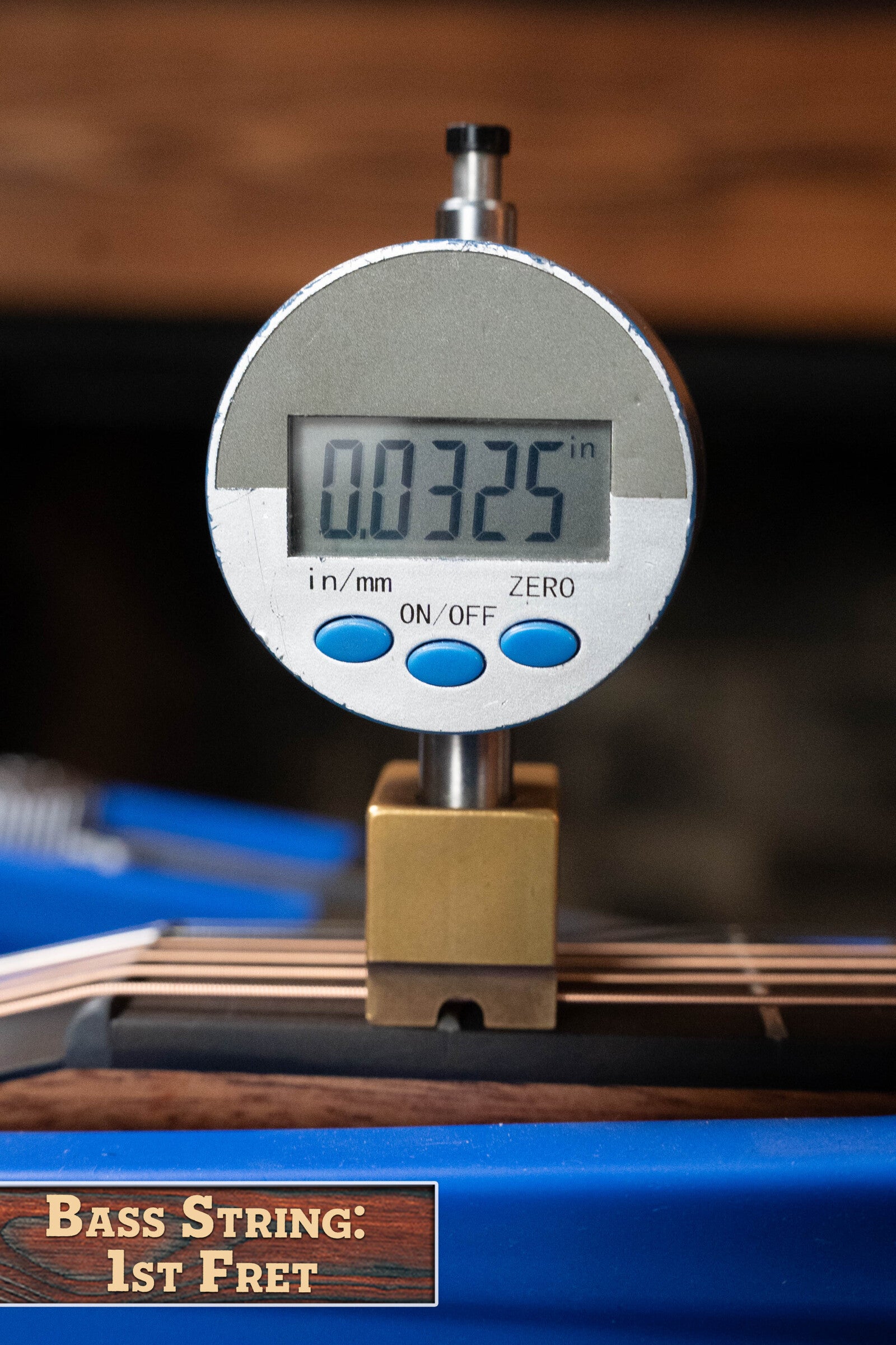 A digital gauge reads 0.0325", measuring the string height at the 1st fret of a Furch Pioneer-ER VTC Engelmann Spruce/Indian Rosewood Cutaway Travel Guitar. A label below states “Bass String: 1st Fret” beside its sleek cutaway profile.