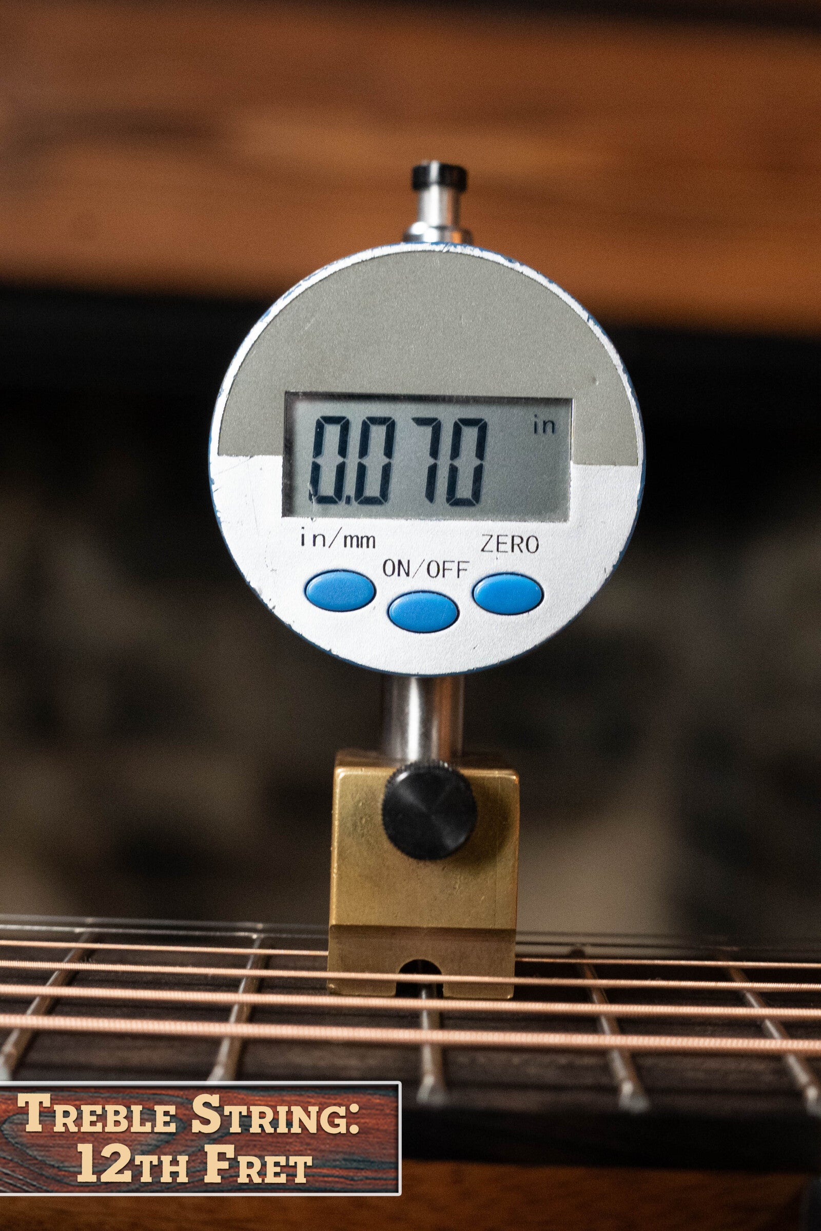 A digital caliper measures treble string height at the 12th fret of the Furch Pioneer-ER VTC Engelmann Spruce/Indian Rosewood Cutaway Travel Guitar, showing 0.070 inches. Text reads: Treble String: 12th Fret.