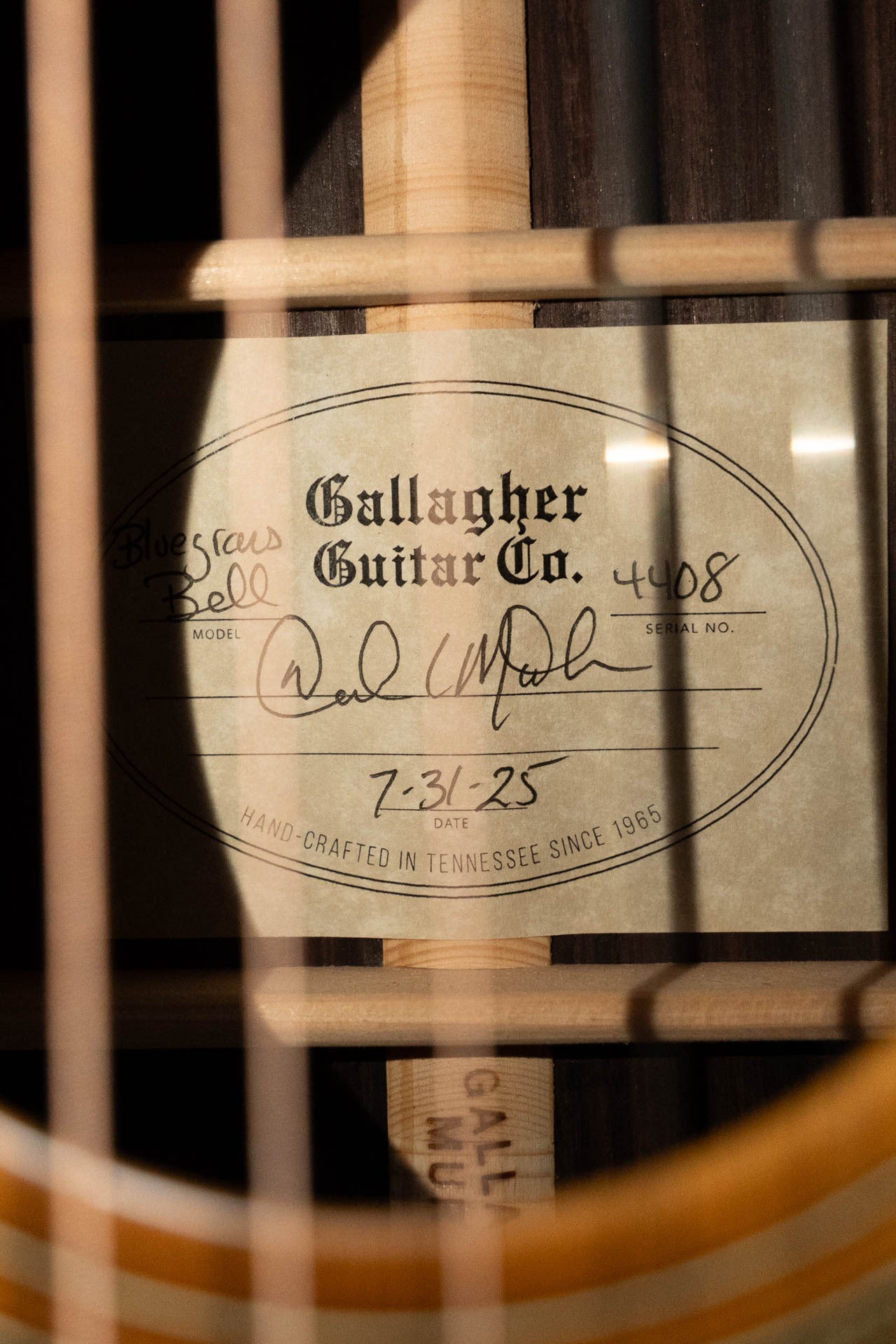 A close-up of a Gallagher Guitar Co. The Bluegrass Bell Torrefied Adirondack/Rosewood Dreadnought Acoustic Guitar #4408 label, showing handwritten model info, serial 4408, signature, dated 7-31-25; handcrafted in Tennessee since 1965.