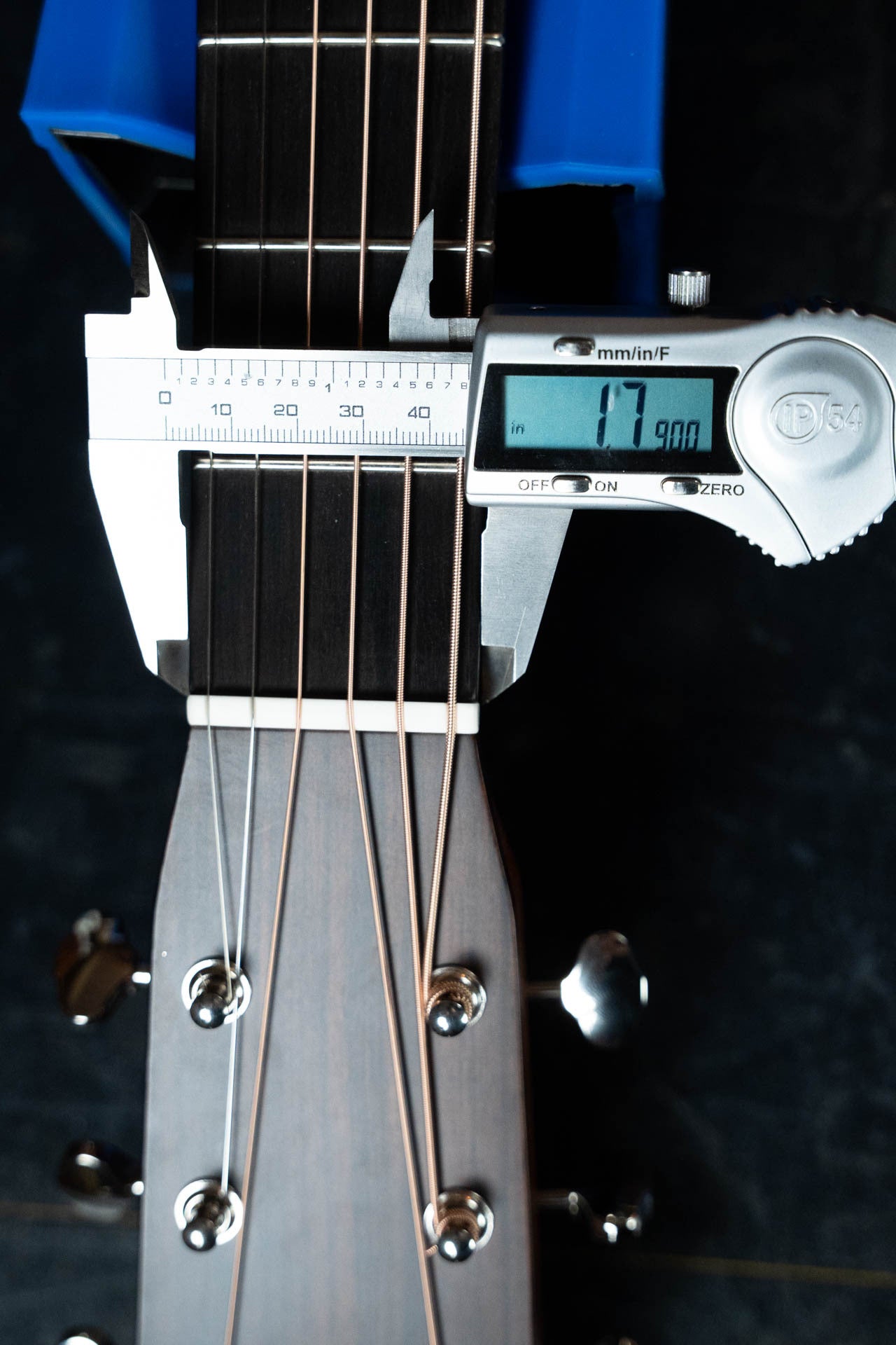 A digital caliper measures the nut width of a Gallagher Guitar Co. The Bluegrass Bell Torrefied Adirondack/Rosewood Dreadnought Acoustic Guitar #4408, displaying 1.790 inches on screen, with the headstock and tuning pegs also visible.