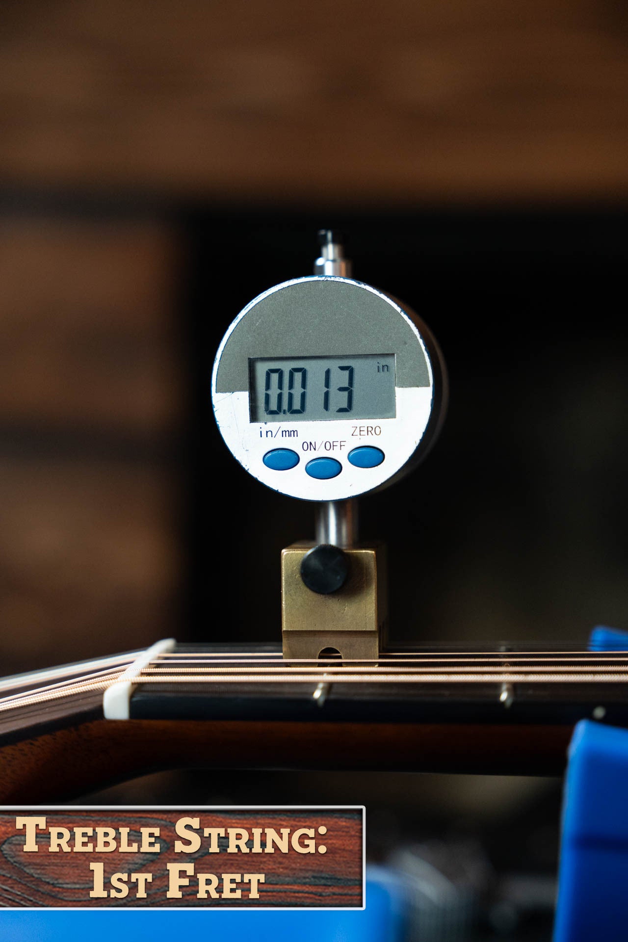 A digital gauge measures the treble string height at the 1st fret on a Gallagher Guitar Co. The Bluegrass Bell Torrefied Adirondack/Rosewood Dreadnought Acoustic Guitar #4408, displaying a reading of 0.013.