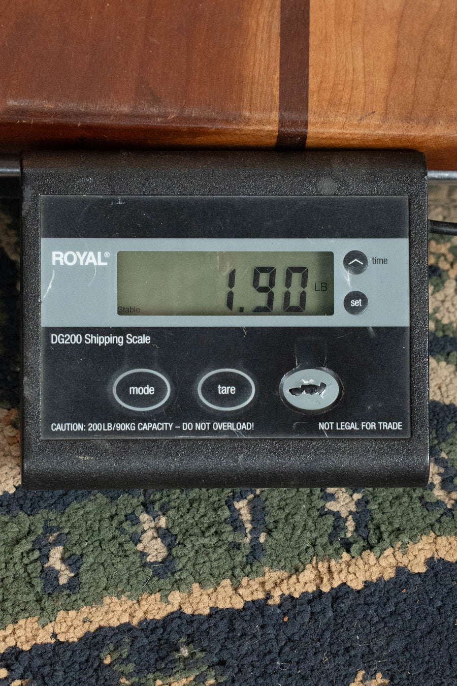 A digital scale shows 1.90 pounds with a black Gibson F-5 Hall of Fame Monroe Cremona Burst Mandolin GH partially visible on top, resting on patterned carpet.