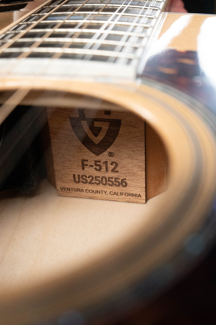 Close-up of Guild F-512E 12-string jumbo guitar soundhole with Sitka spruce top and label inside. - Guild F-512E Sitka/Flamed Maple 12 String Maple Blonde Jumbo Guitar w/LR Baggs Electronics #0556 - Default Title