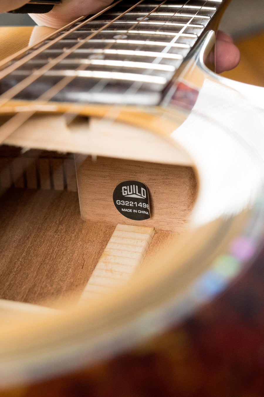 Close-up of natural wood OM cutaway guitar body and fretboard with visible Guild label inside soundhole. - Guild OM-140CE Sitka/African Mahogany Natural OM Cutaway Guitar w/Electronics #4964 - Default Title