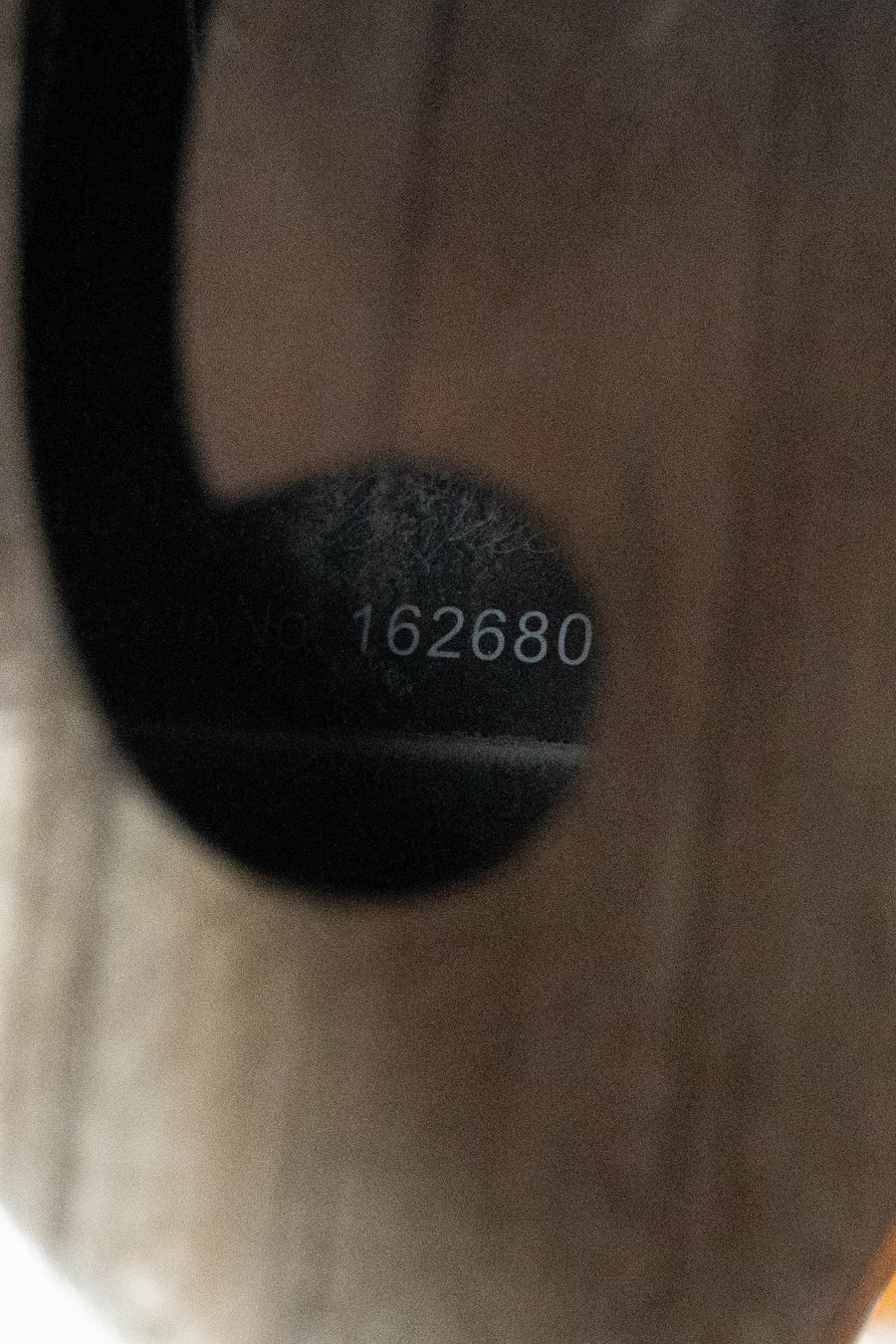 A close-up shows "2680" etched in white on a dark, circular surface of the KLOS CT_MA_DA Full Carbon Timber A-Style Acoustic Mandolin by KLOS Guitars, with the wooden grain of its adjustable ebony bridge visible in the background.
