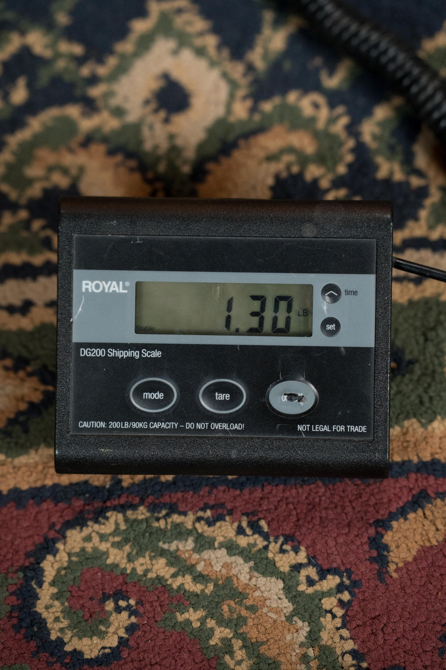 Digital scale displaying 1.30 oz on a patterned fabric surface with a coiled black cable nearby. - KR Strings Artist Spruce/Rosewood Acoustic Mandolindo #0001 - Default Title