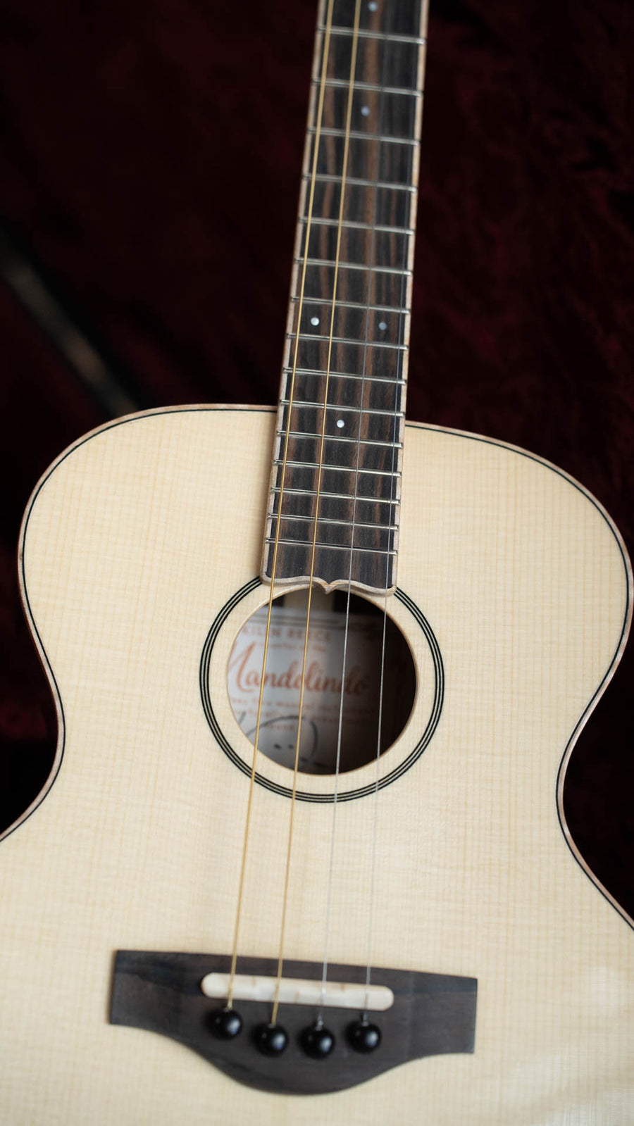 Acoustic mandolindo with a light spruce top, rosewood bridge, and dark wood fretboard on a burgundy background. - KR Strings Artist Spruce/Rosewood Acoustic Mandolindo #0002 - Default Title