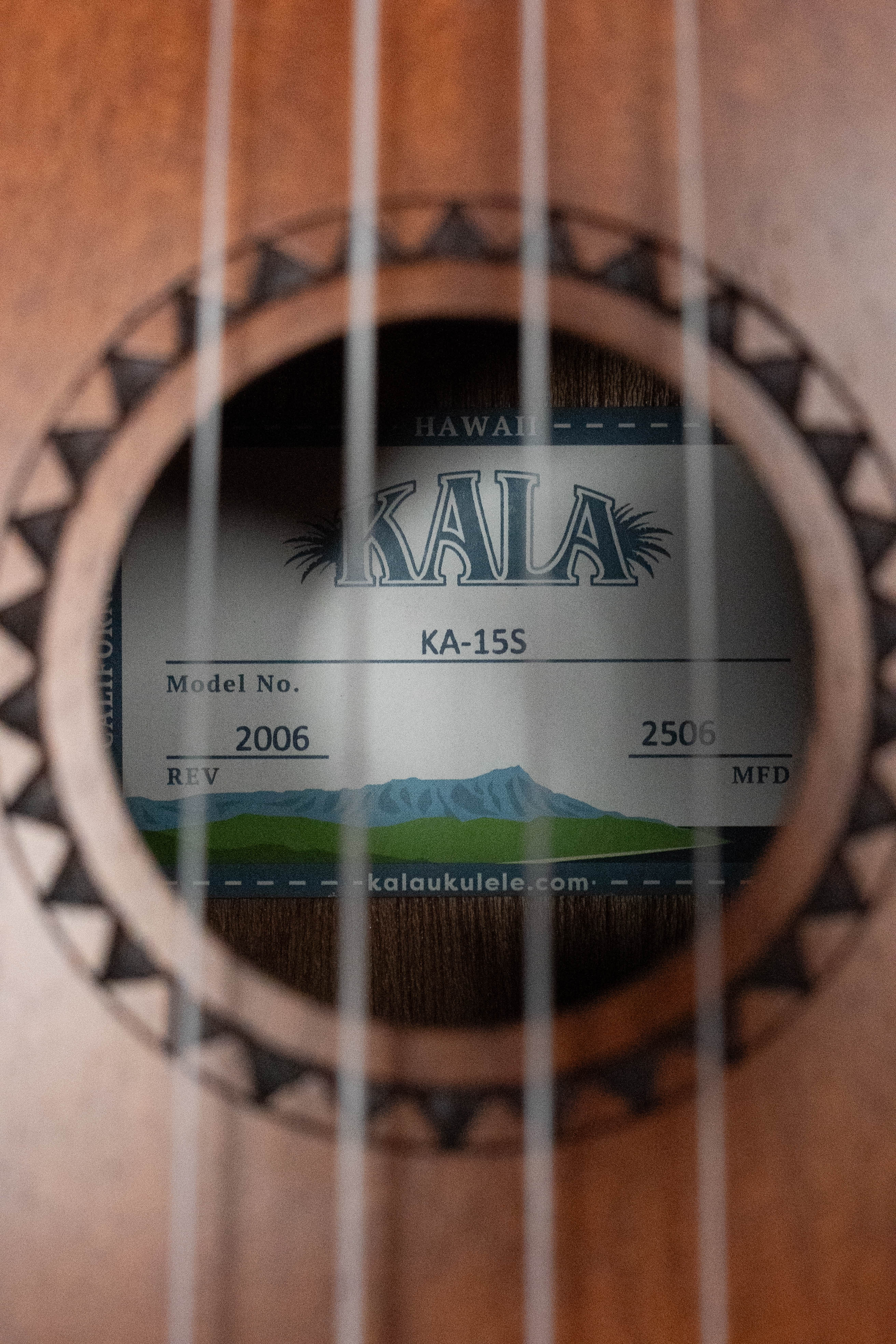 Close-up of Kala KA-15S satin mahogany soprano ukulele soundhole with tribal rosette design and label inside. - Kala KA-15S Satin Mahogany Soprano Ukulele - Default Title