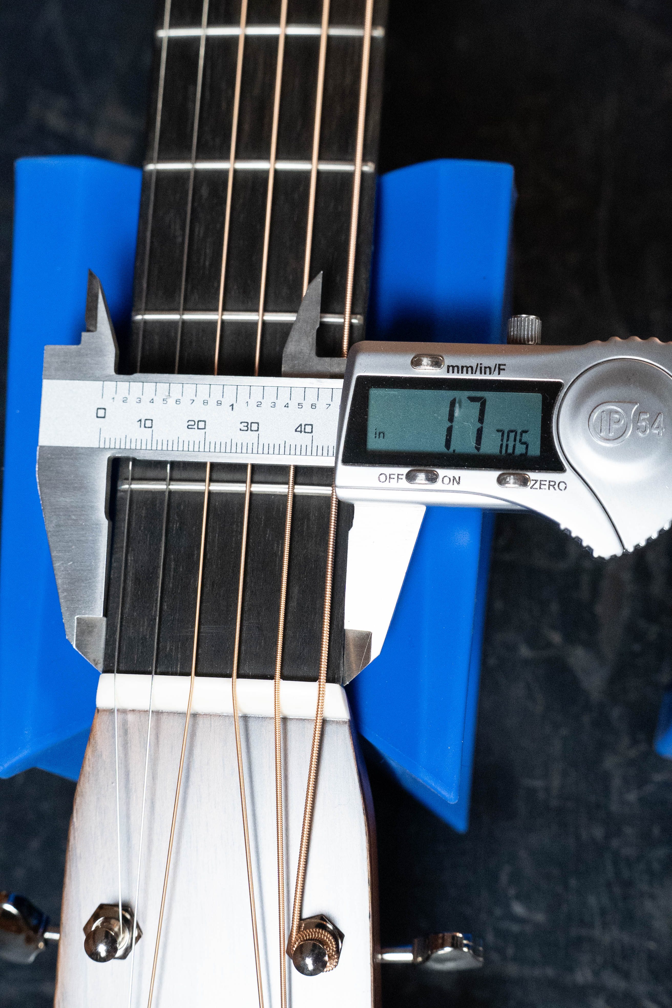 A digital caliper measures the neck width of the Martin & Co. Custom Shop HD-28 Style Spruce/Wild Grain Rosewood "D" Dreadnought Acoustic Guitar #7410 at 1.77 inches, with the guitar resting on blue supports near the headstock.