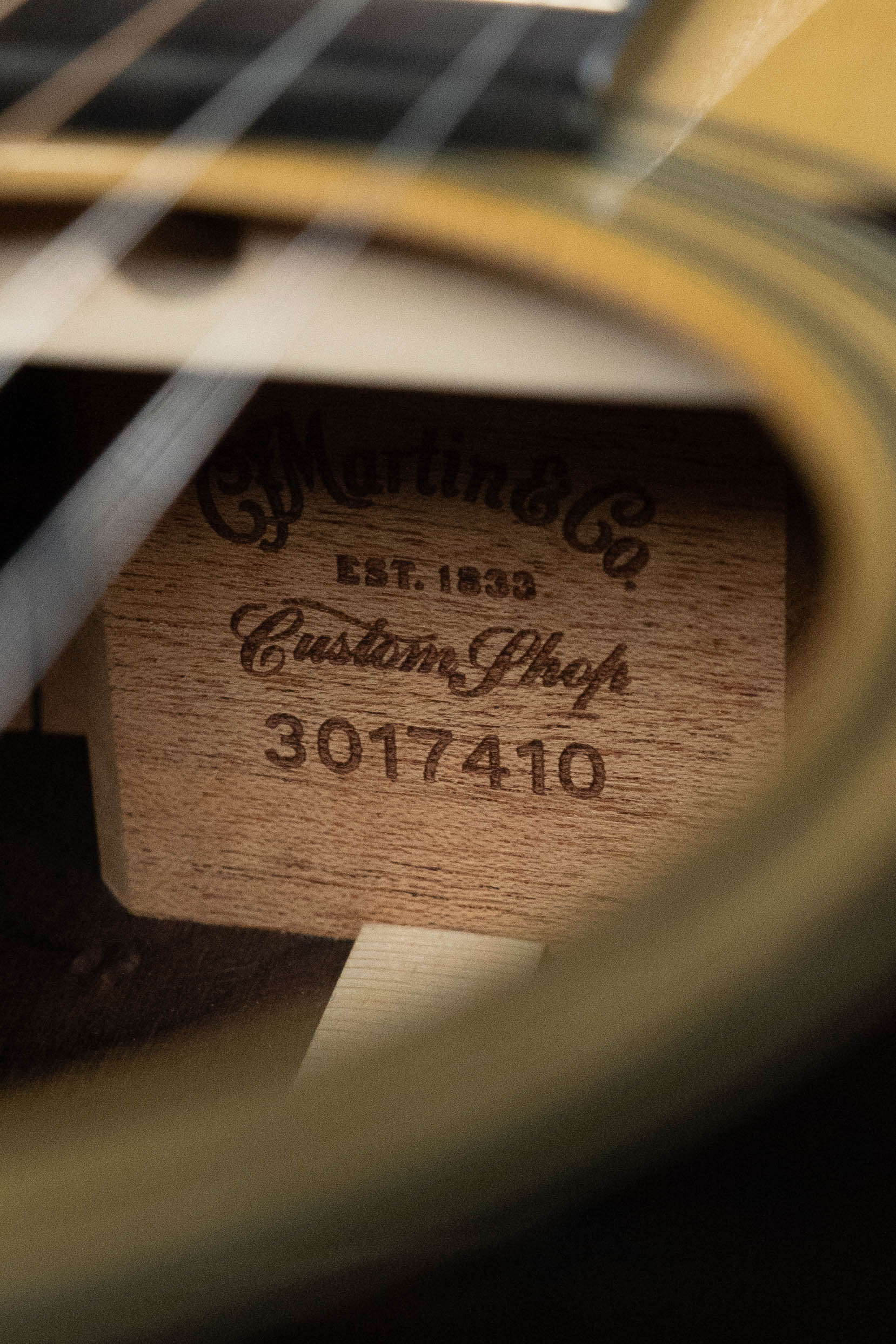 Close-up of a Martin & Co. Custom Shop HD-28 Style Spruce/Wild Grain Rosewood Custom "D" Dreadnought Acoustic Guitar #7410 interior label, visible through the sound hole and strings.