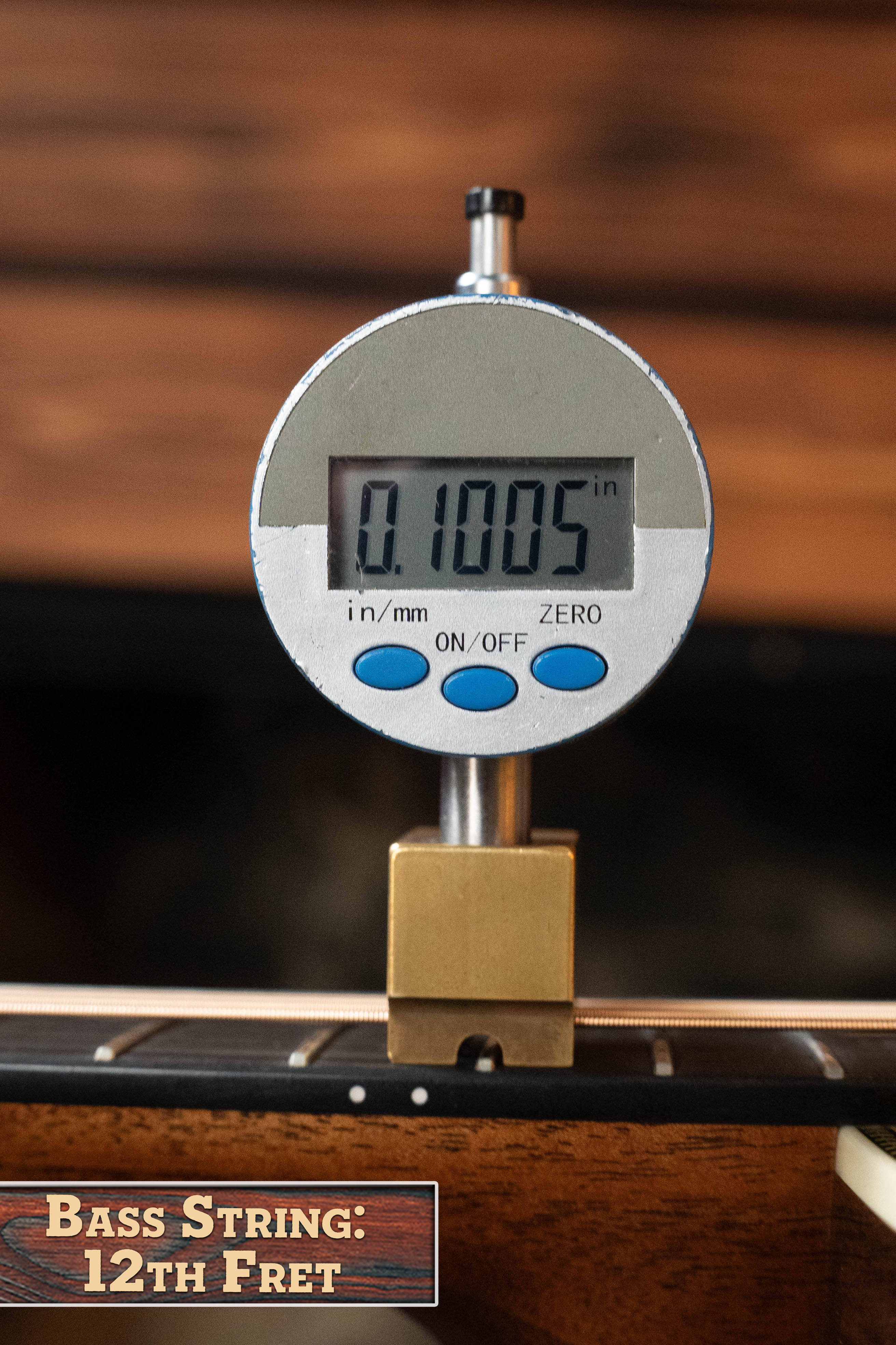 A digital gauge shows a 12th-fret bass string height of 0.1005 inches beside a Martin & Co. Custom Shop HD-28 Style Spruce/Wild Grain Rosewood Dreadnought Acoustic Guitar #7410, labeled “Bass String: 12th Fret.”.
