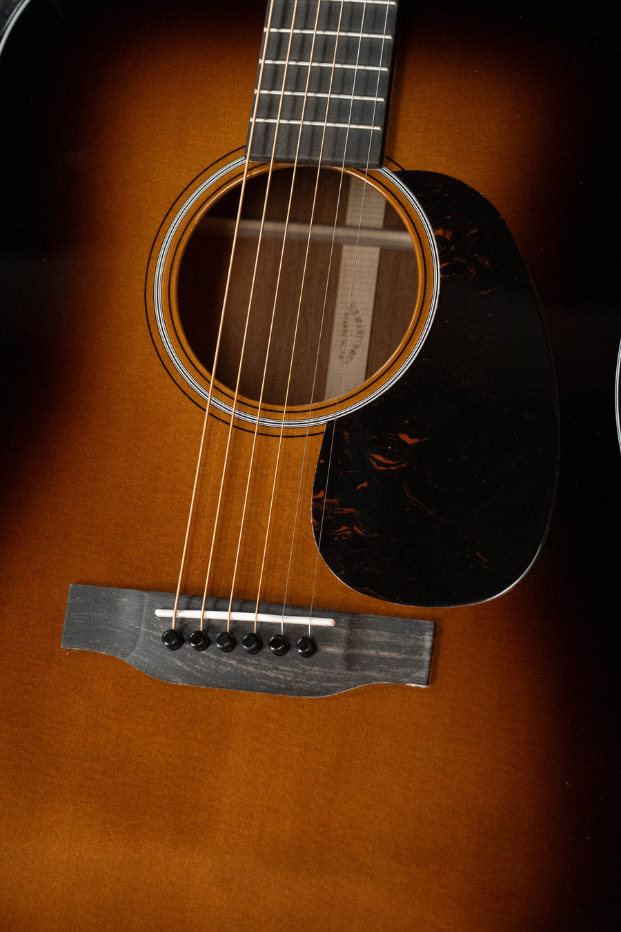 Close-up of a Martin & Co. D-18 Spruce/Mahogany 1935 Gloss Sunburst Finish Dreadnought Acoustic Guitar #2409, highlighting the strings, sound hole, pickguard, and fretboard.