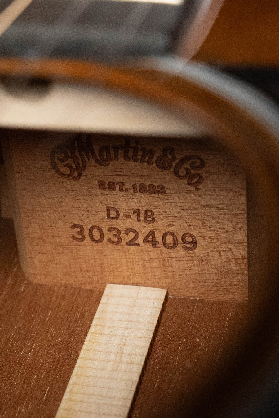 Close-up of the Martin & Co. D-18 Spruce/Mahogany 1935 Gloss Sunburst Finish Dreadnought Acoustic Guitar (#2409) interior, showing the brand logo, model name, and serial number stamped on the wood block.