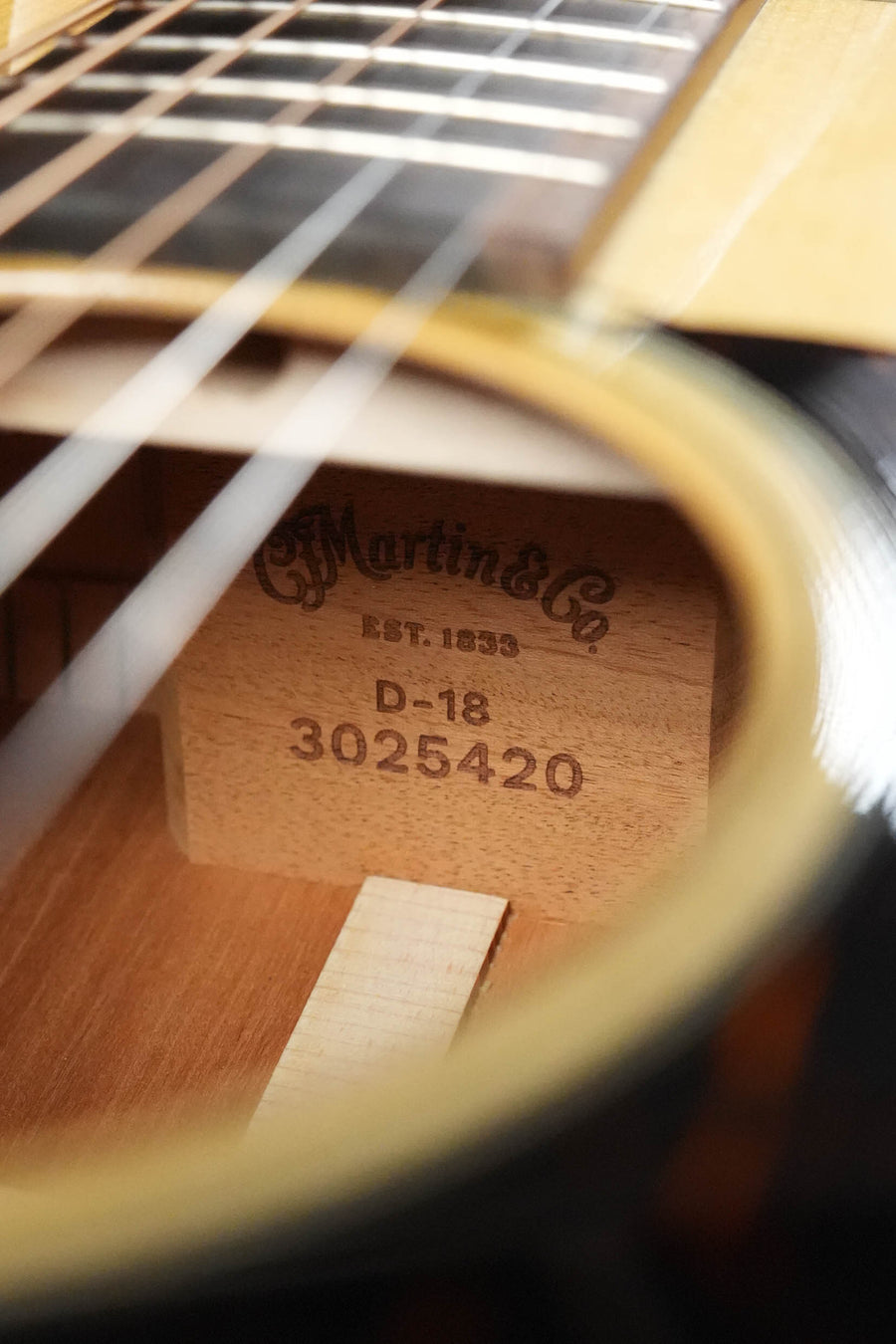 A close-up through the sound hole of the Martin & Co. D-18 Spruce/Mahogany Gloss Finish Dreadnought Acoustic Guitar #5420 shows an internal label on the wooden block with the brand name and model details inside the spruce top body.