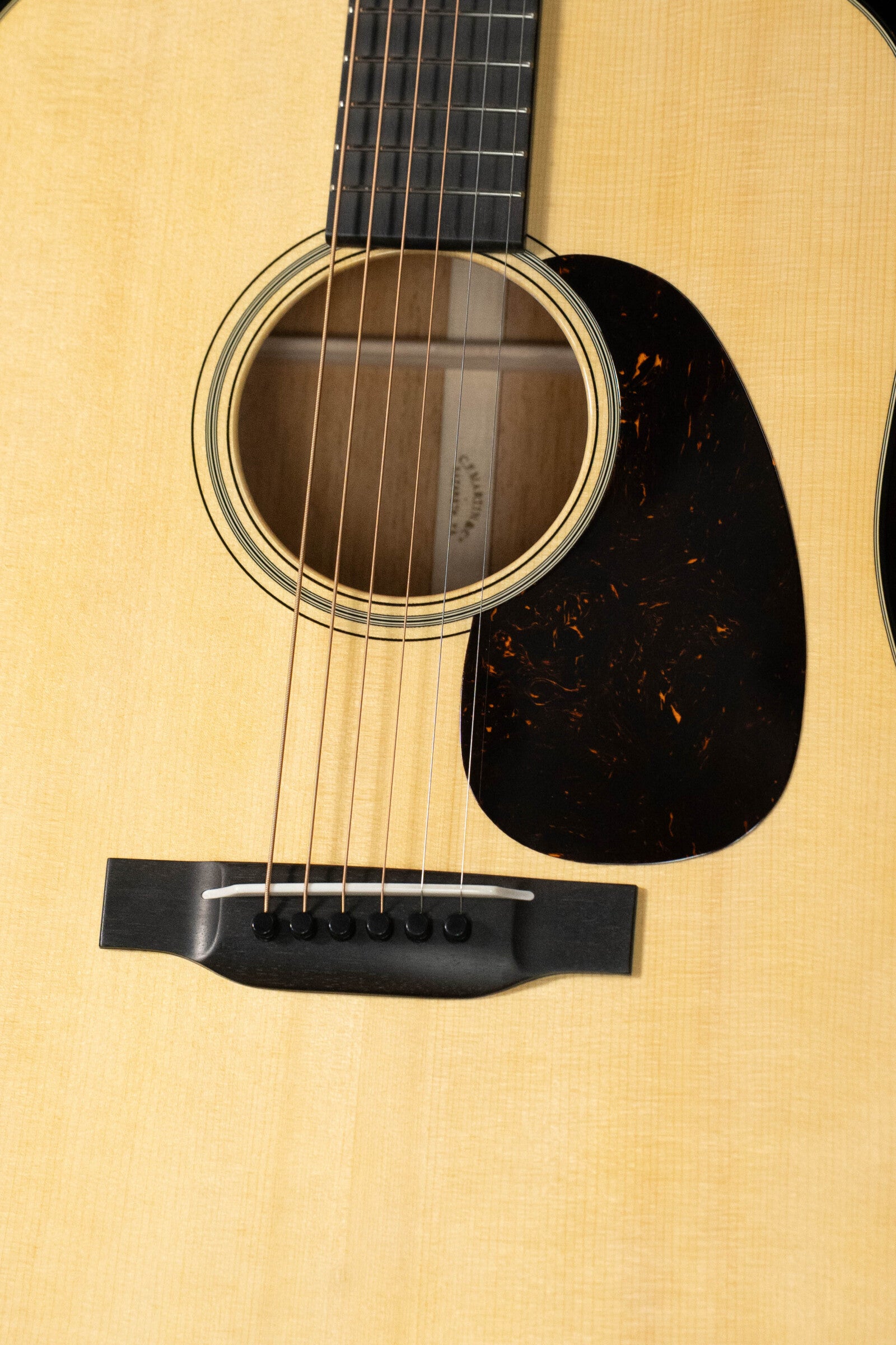 Close-up of the Martin Custom Shop D-18V Adirondack/Mahogany Dreadnought Acoustic Guitar #6905 by Martin & Co., featuring an Adirondack spruce top, detailed sound hole ring, dark pickguard, and classic bridge on a light wood body.