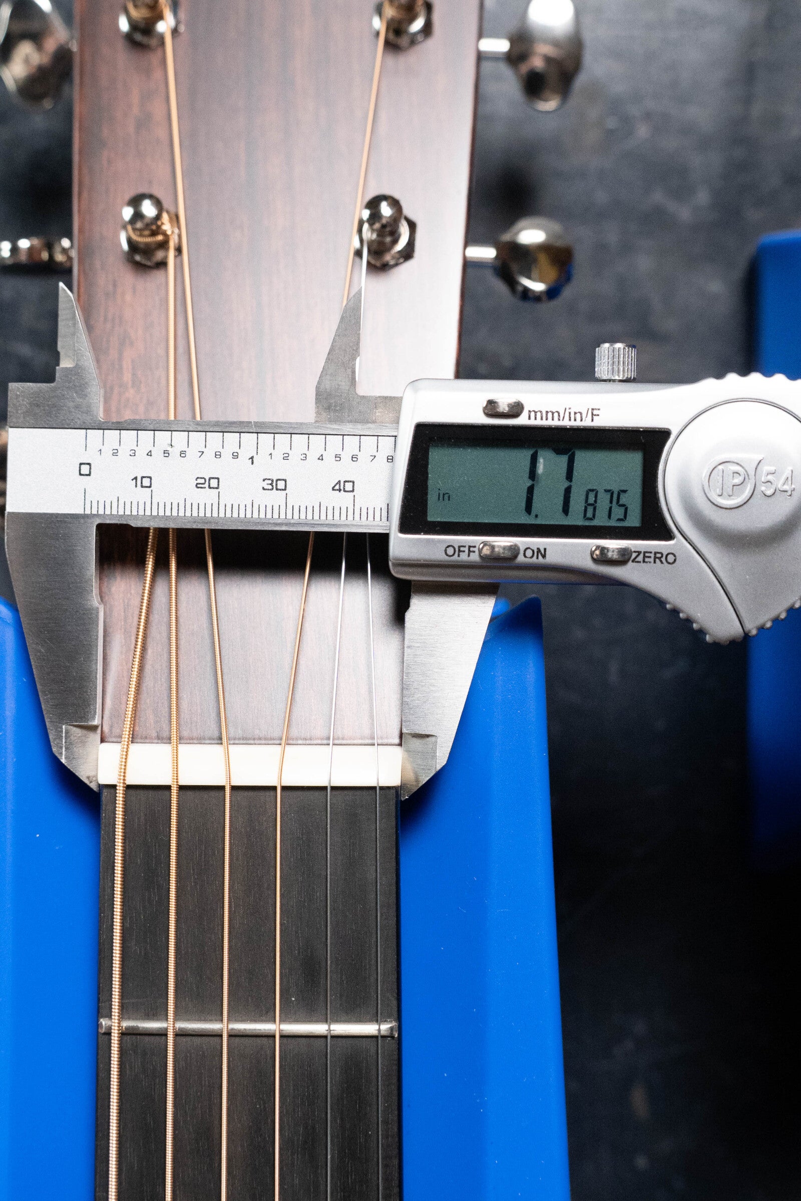 A digital caliper measures the nut width of a Martin & Co. Custom Shop D-18V Adirondack/Mahogany Dreadnought Acoustic Guitar (#6905) at 1.8875 inches, as the vintage guitar rests in blue supports with metal tuning pegs visible.