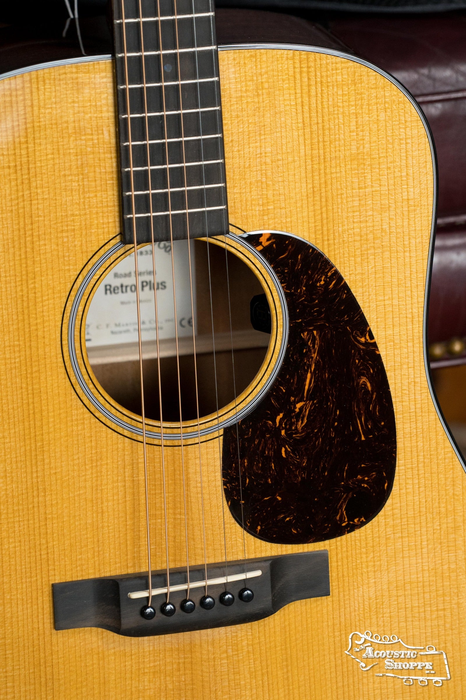 Close-up of a Martin & Co. DE Retro Plus Dreadnought Guitar with torrefied spruce and mahogany body, brown tortoiseshell pickguard, visible "Retro Plus" label inside, and Acoustic Shoppe logo highlighting its vintage-inspired tone.