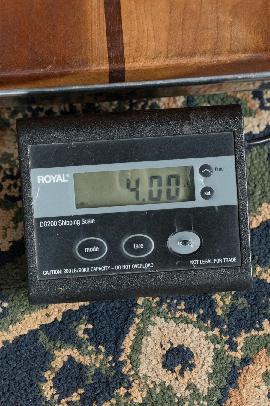 A *New 2025 Model* Martin D Jr E Streetlegend Burst Spruce/Sapele Aged-Look Dreadnought Guitar by Martin & Co. sits on a patterned carpet next to a “ROYAL DG200” digital shipping scale showing 4.00 lbs and featuring a 200lb/90kg capacity warning.