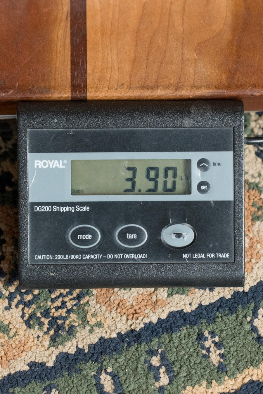 A digital shipping scale on a patterned rug reads 3.90 pounds—ideal for the *New 2025 Model* Martin D Jr E Streetlegend Burst Spruce/Sapele Aged-Look Dreadnought Guitar w/Martin Electronics #3866 by Martin & Co., known for its lightweight build.