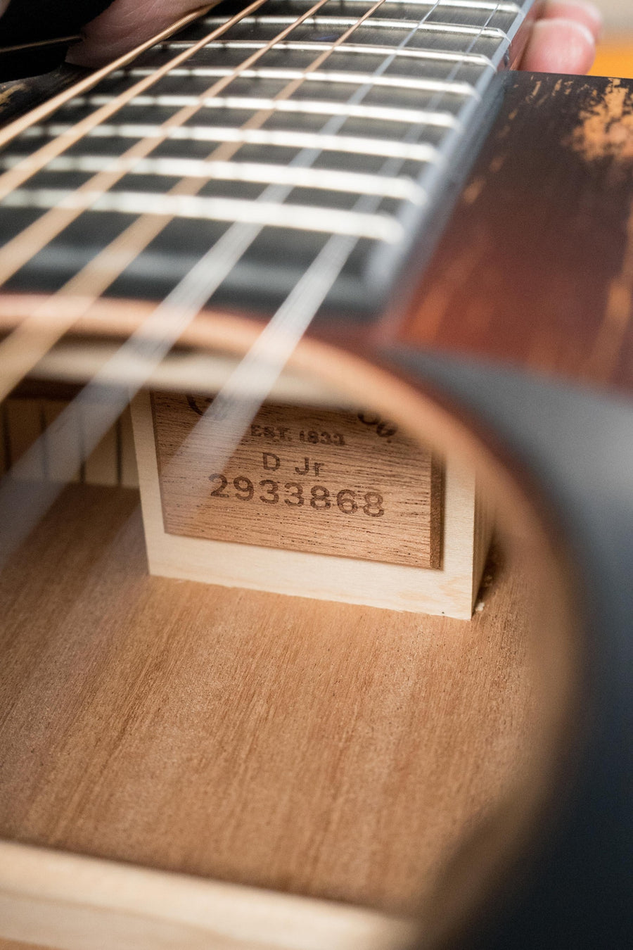 Close-up of a *New 2025 Model* Martin & Co. D Jr E Streetlegend Burst Spruce/Sapele Aged-Look Dreadnought Guitar w/Martin Electronics (#3868), highlighting its sound hole, strings, label, and vintage-inspired craftsmanship.