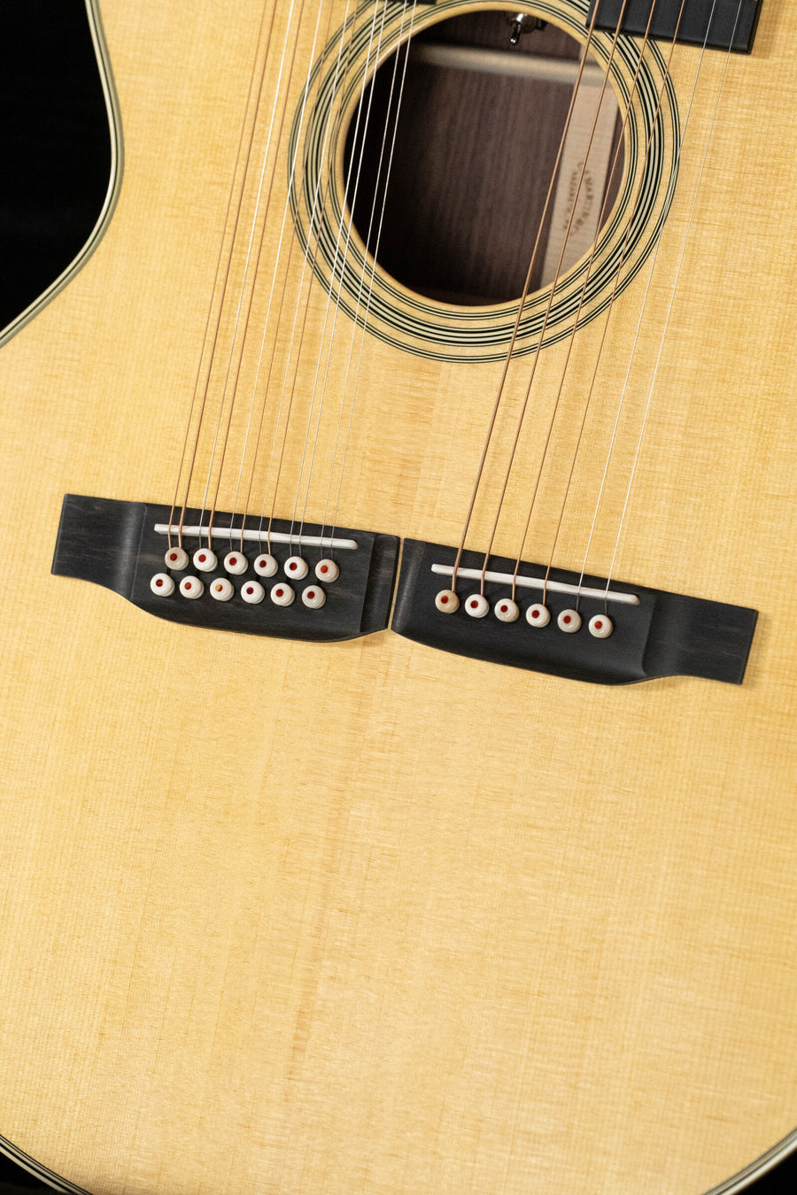 Close-up of a Martin & Co. Grand J-28E DN Spruce/Rosewood Double Neck Jumbo Guitar (#3046) with Fishman pickup, showing its light wood body, double necks, multiple strings, sound hole, and part of the fretboard.