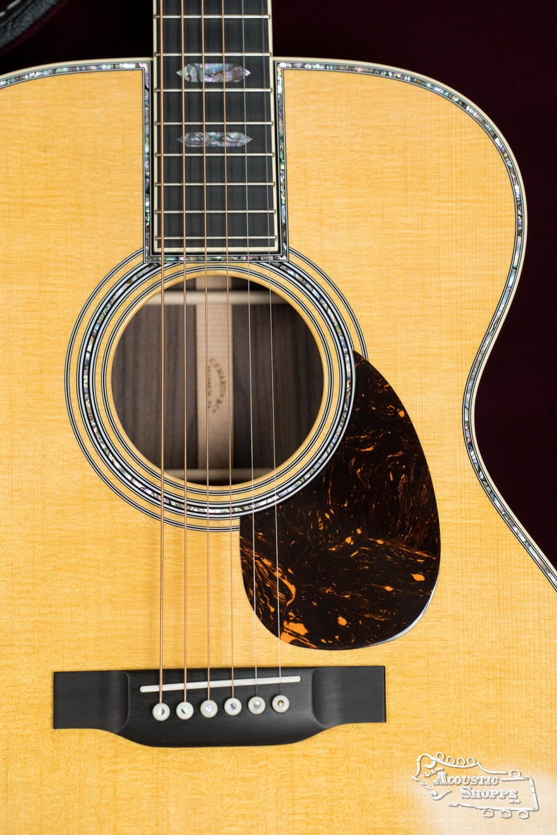 Close-up of a Martin & Co. *NEW 2025* OM-45 Spruce/Rosewood Acoustic Guitar #5120, highlighting abalone inlay on the soundhole and edges, tortoiseshell-patterned pickguard, six strings, and a light spruce rosewood finish.
