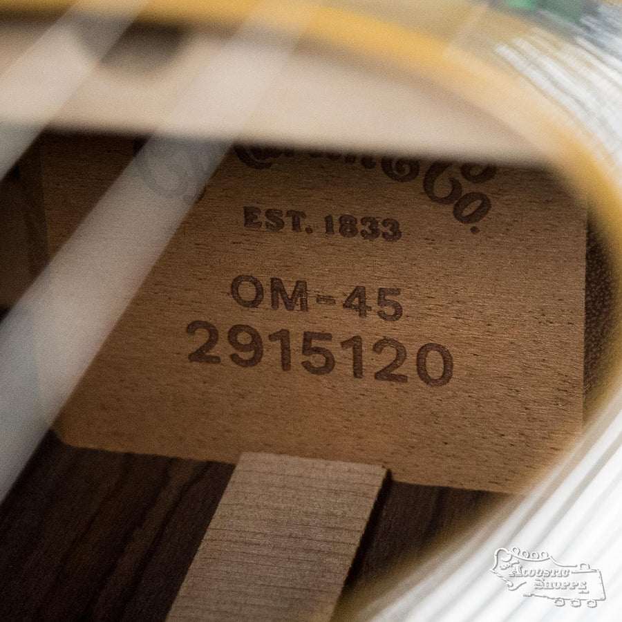 Close-up of a Martin & Co. *NEW 2025* OM-45 Spruce/Rosewood Acoustic Guitar #5120 interior, showing the label with "Est. 1833, OM-45, 2915120" indicating its model and serial number burned into the wood.