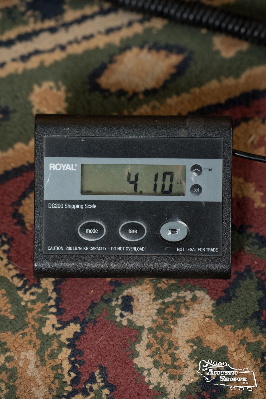 A Royal DG200 digital scale on a patterned rug shows 4.10 lbs—the ideal weight for the Martin & Co. *NEW 2025* OM-45 Spruce/Rosewood OM Acoustic Guitar #5120, known for its balanced tone and scalloped X-bracing.