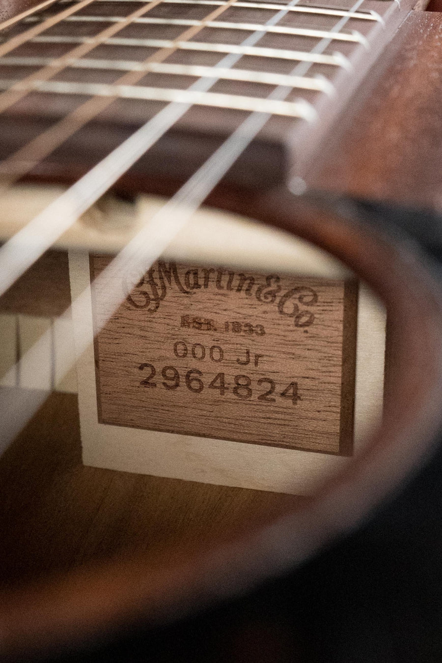 Close-up of Martin OOO Jr E all-sapele guitar label inside soundhole with strings and fretboard visible. - Martin OOO Jr E All Sapele OOO Guitar w/Martin Electronics #4824 - Default Title