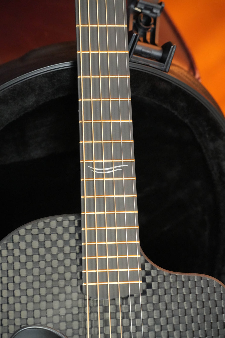 Close-up of a McPherson Guitars Carbon Fiber Touring Series Blackout Basketweave Guitar w/L.R. Baggs Element Pickup #0061, featuring gold strings, neck, body detail, and included case—ideal for touring musicians.