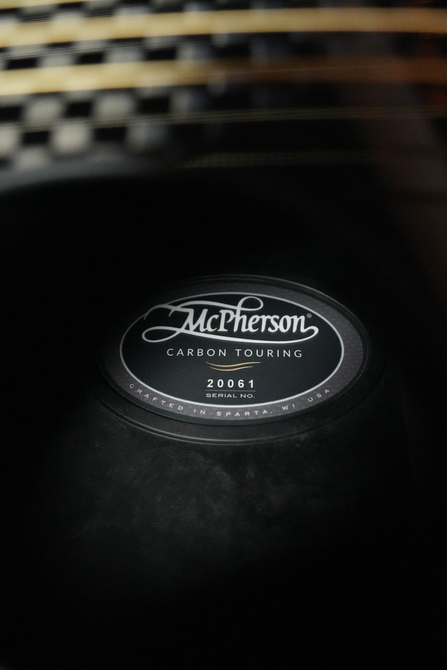 Close-up of the inside label on a McPherson Guitars Carbon Fiber Touring Series Blackout Basketweave Guitar w/L.R. Baggs Element Pickup #0061, crafted in Sparta, MI, with its unique blackout basketweave interior visible.