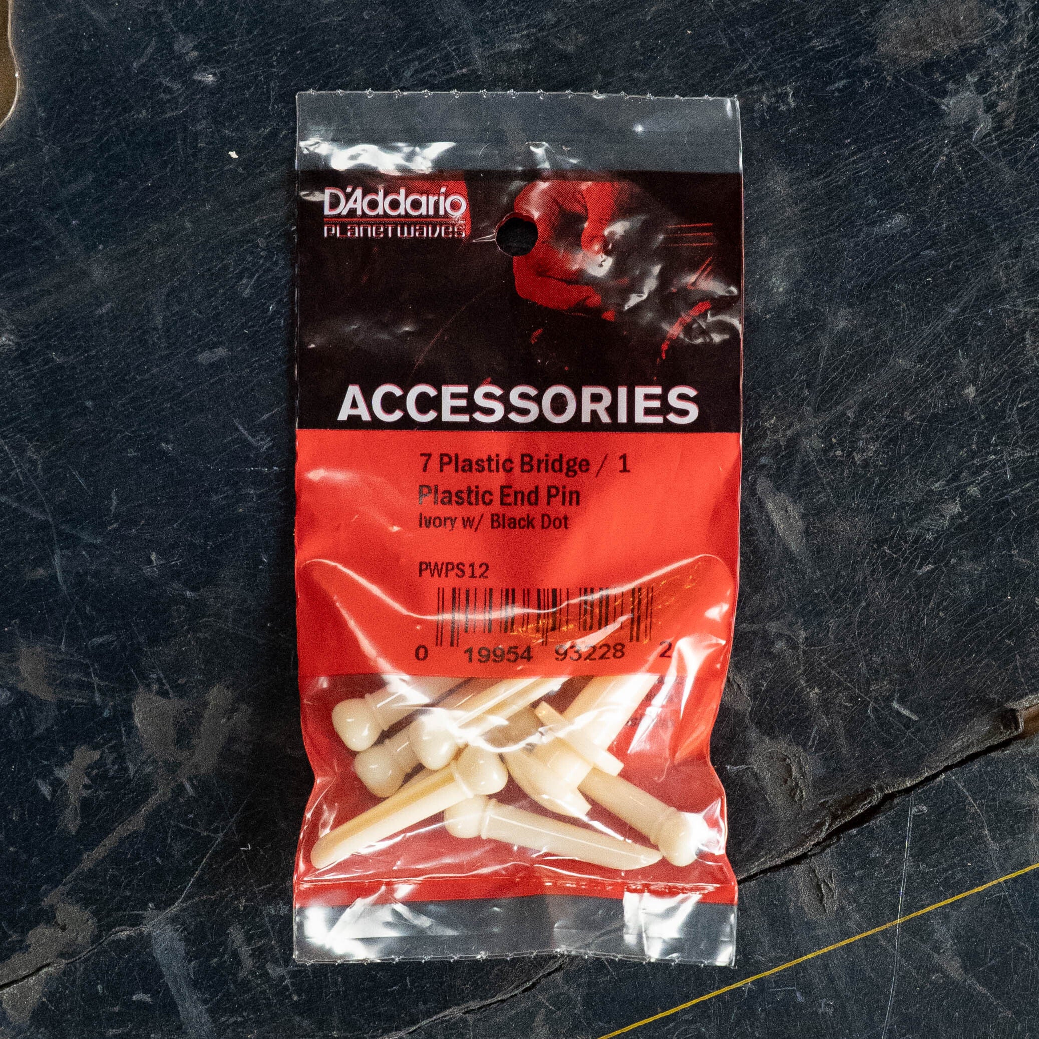 A set of 7 D'Addario Injected Molded Bridge Pins with End Pin, in ivory with ebony dot (PWPS12), designed for acoustic guitars.