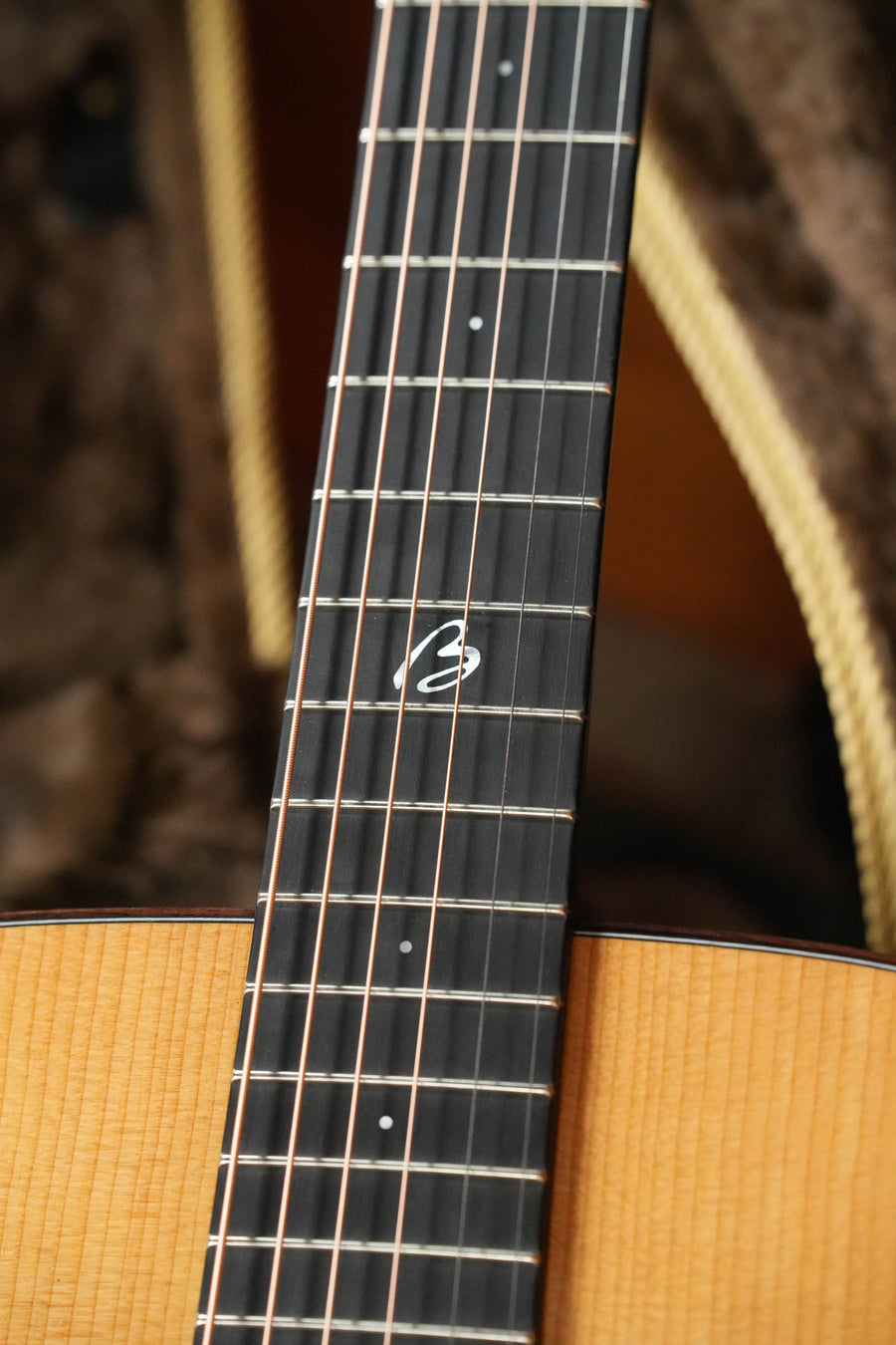 A close-up of the Boucher Guitars *New 2026 Model* BG-42T-G Bluegrass Goose Gold Pack Dreadnought #1082 highlights its metal frets, distinct 12th-fret inlay, and torrefied Adirondack body edge.